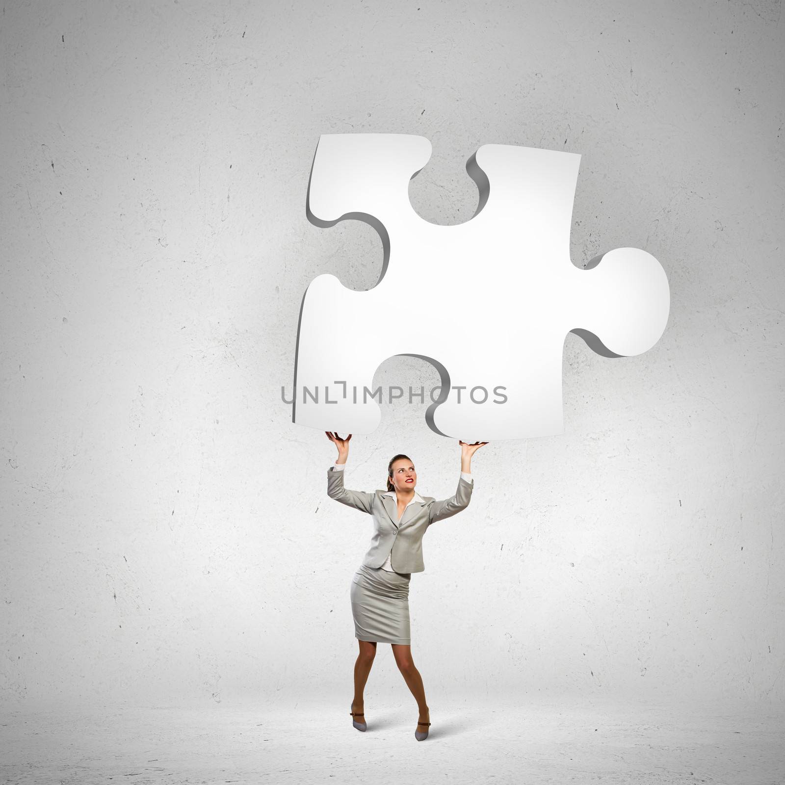 Image of businesswoman holding puzzle element above head