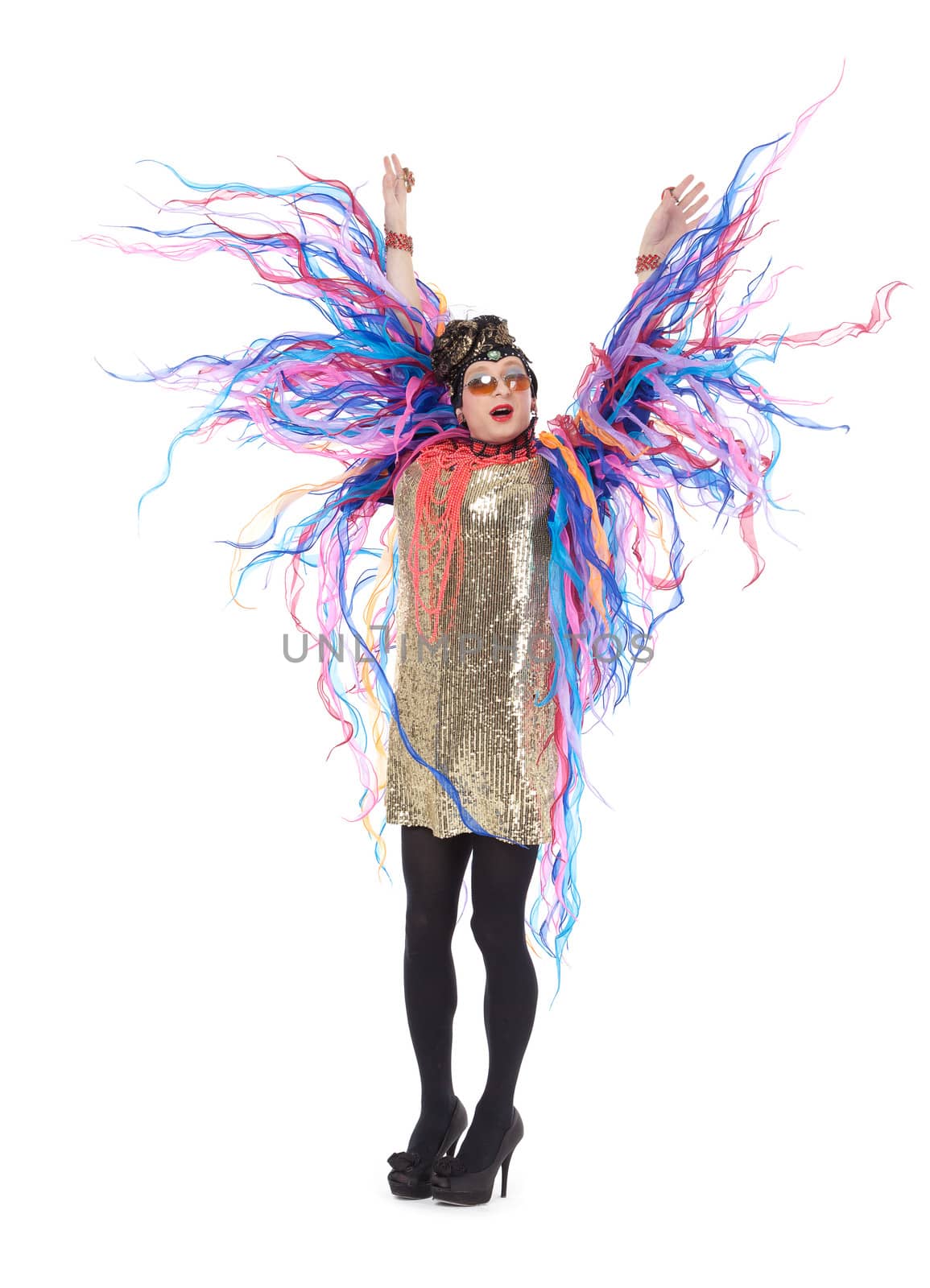 Fashion conscious drag queen in a glitzy gold dress, high heeled stilettos and with streamers performing in a show, isolated on white