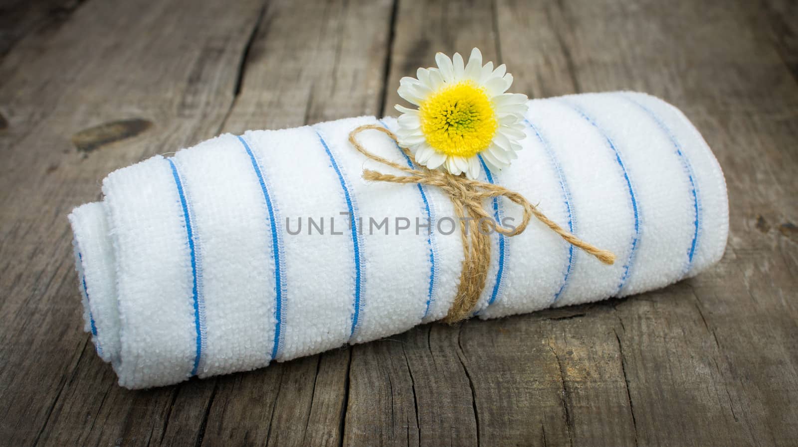 A Towel With a Flower on wooden background