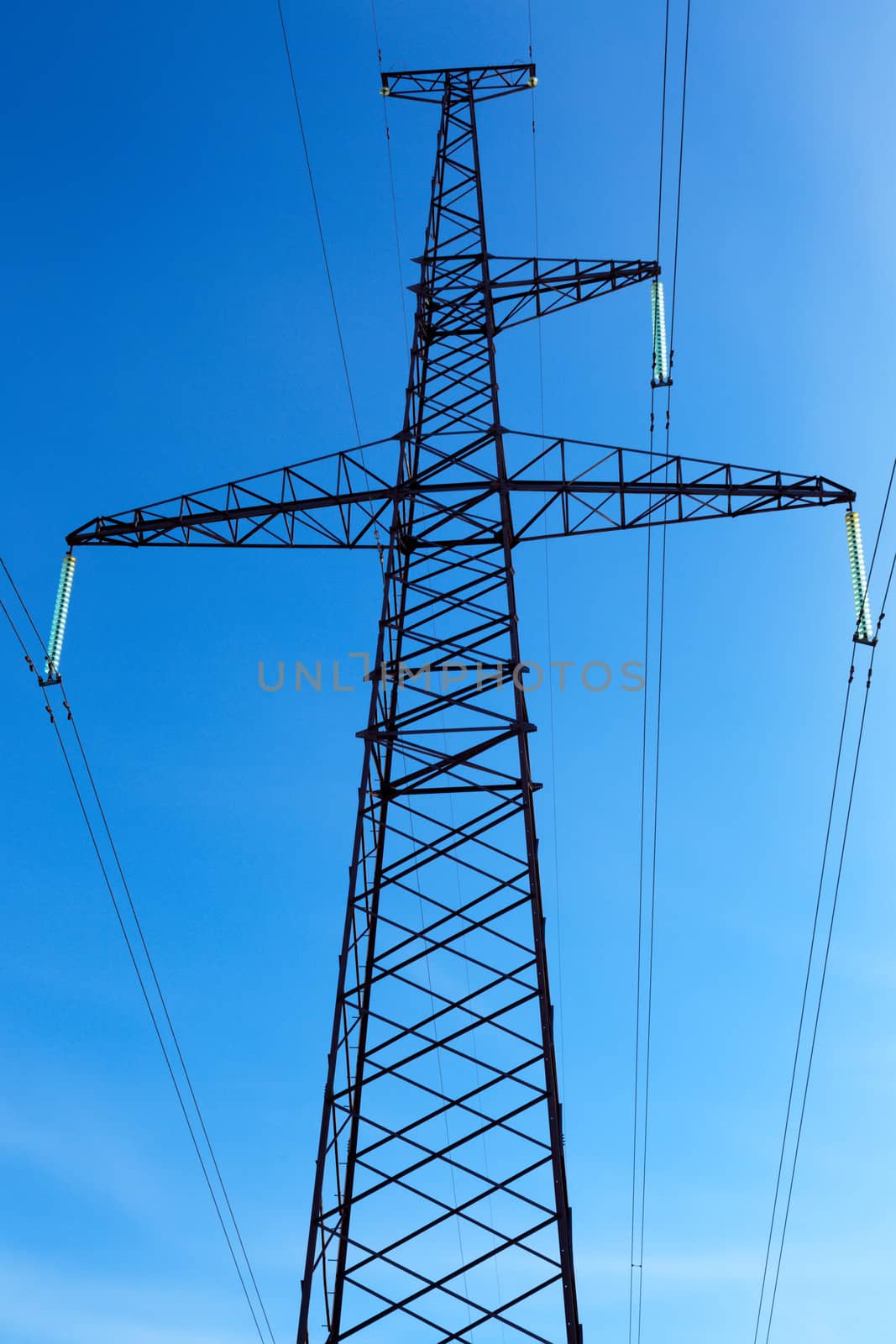Support of a line of high-voltage electricity transmissions on a background of the blue sky