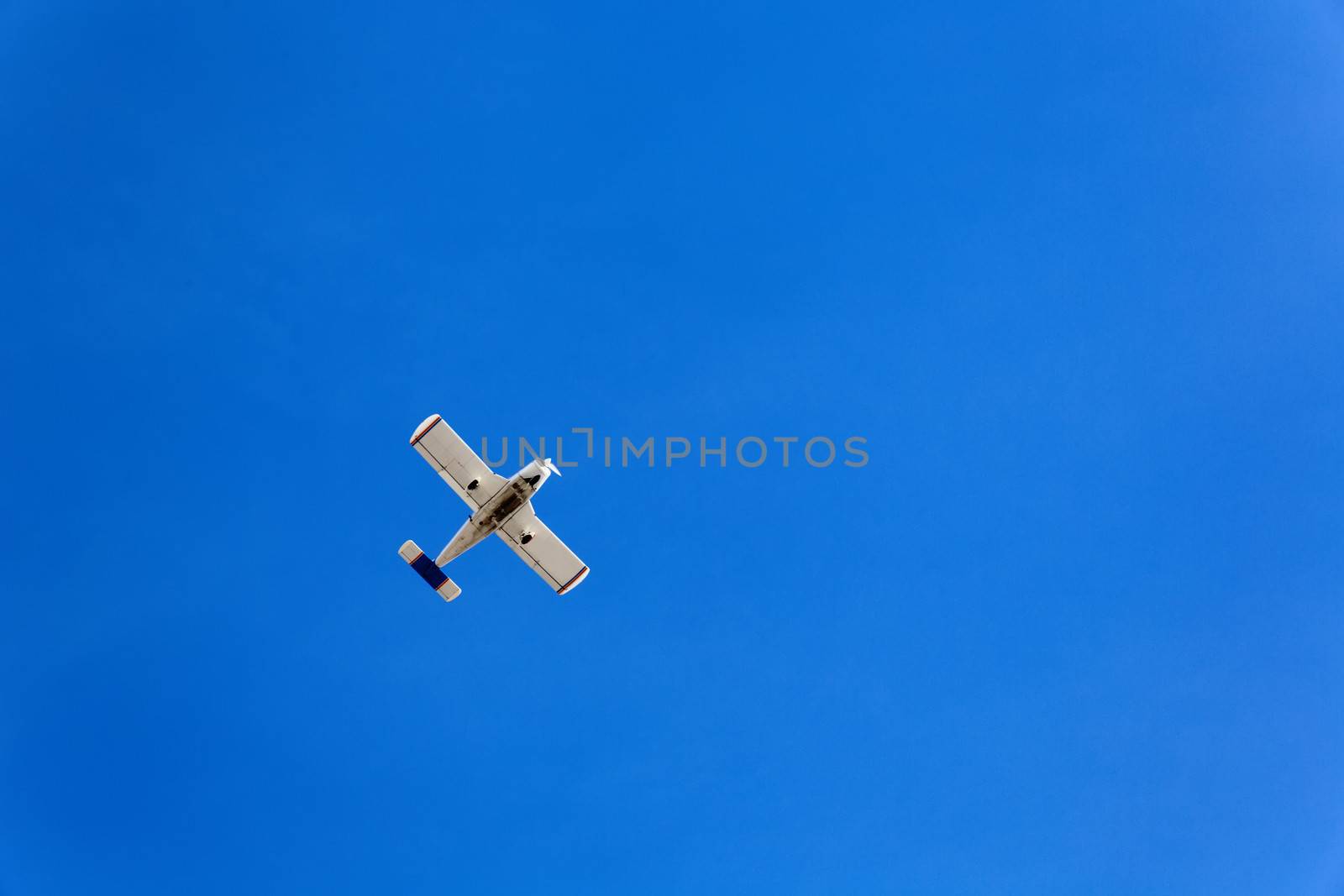 Small flying aircraft in a blue sky