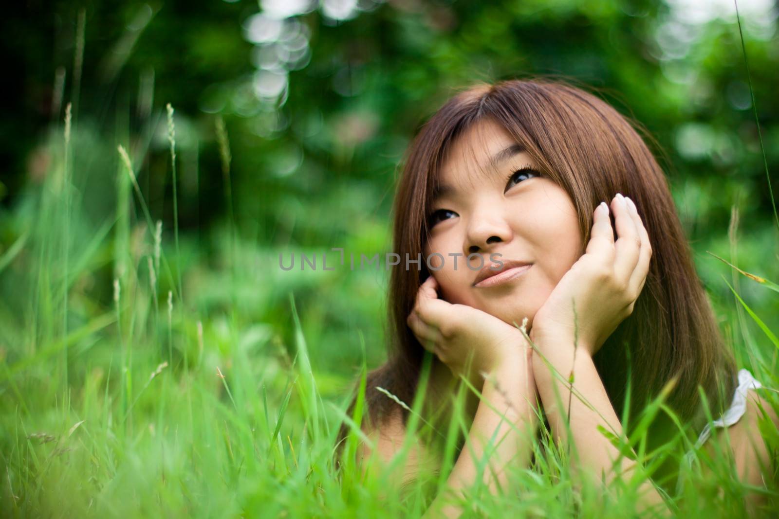 Summer. Portrait of pretty asiatic girl dreaming at meadow