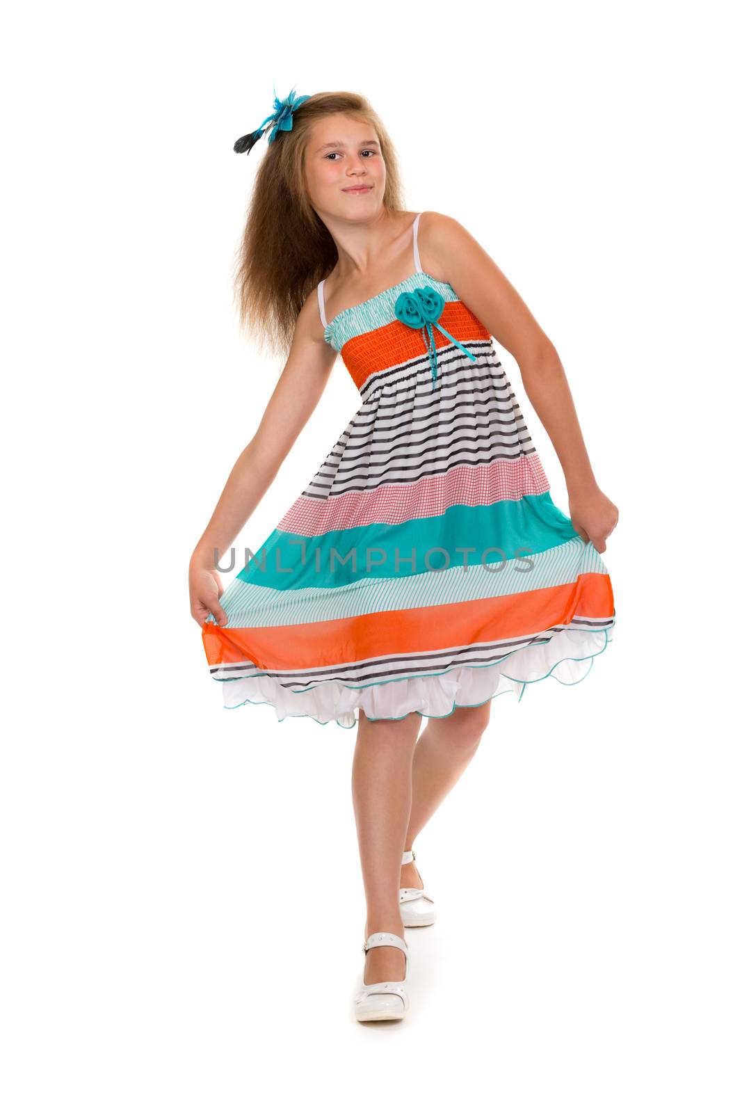 11 year old girl dances in colorful dress in the studio. Isolate on white.