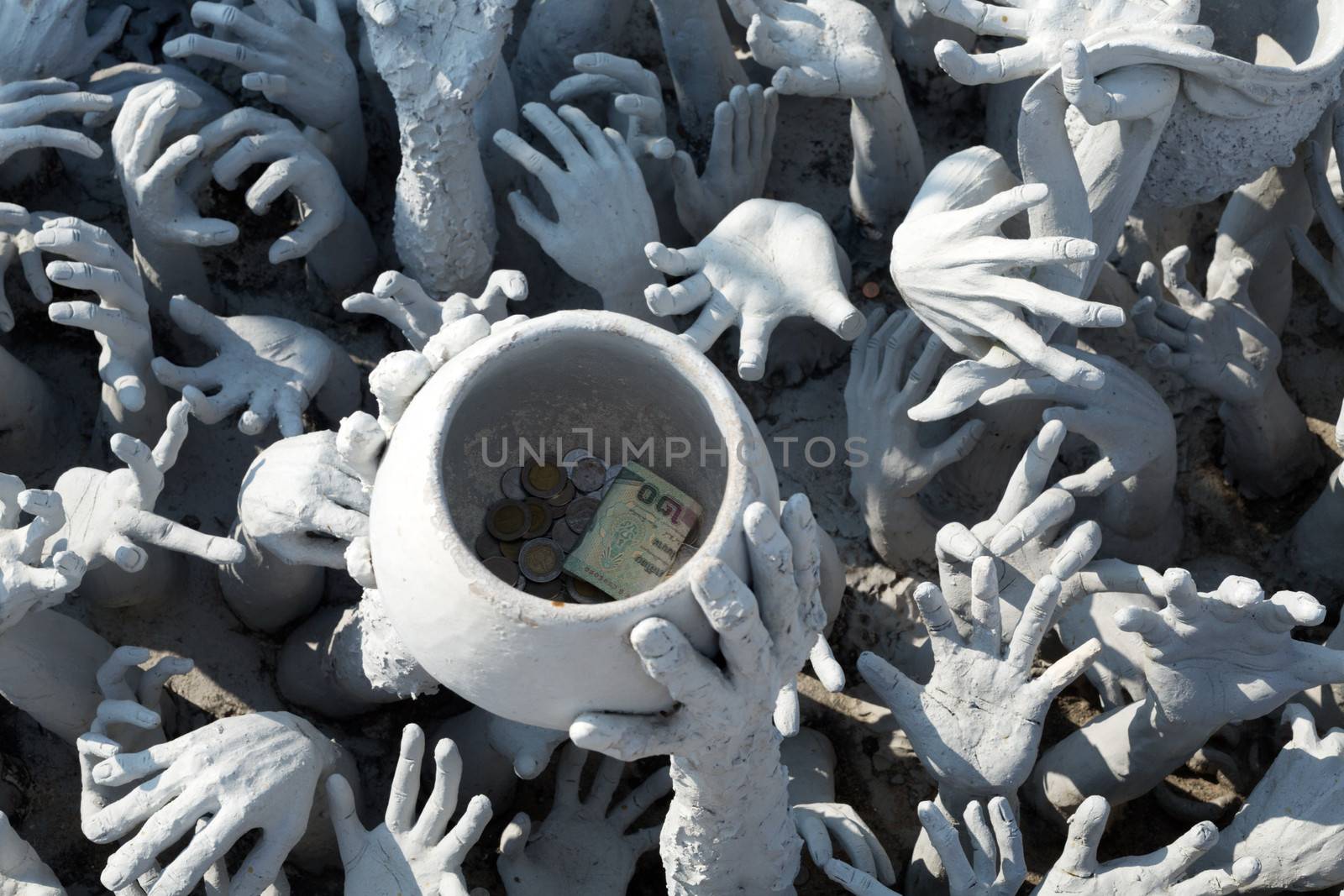 Sculptural composition with his hands and cup. Rong Khun temple, Chiang Rai province, northern Thailand