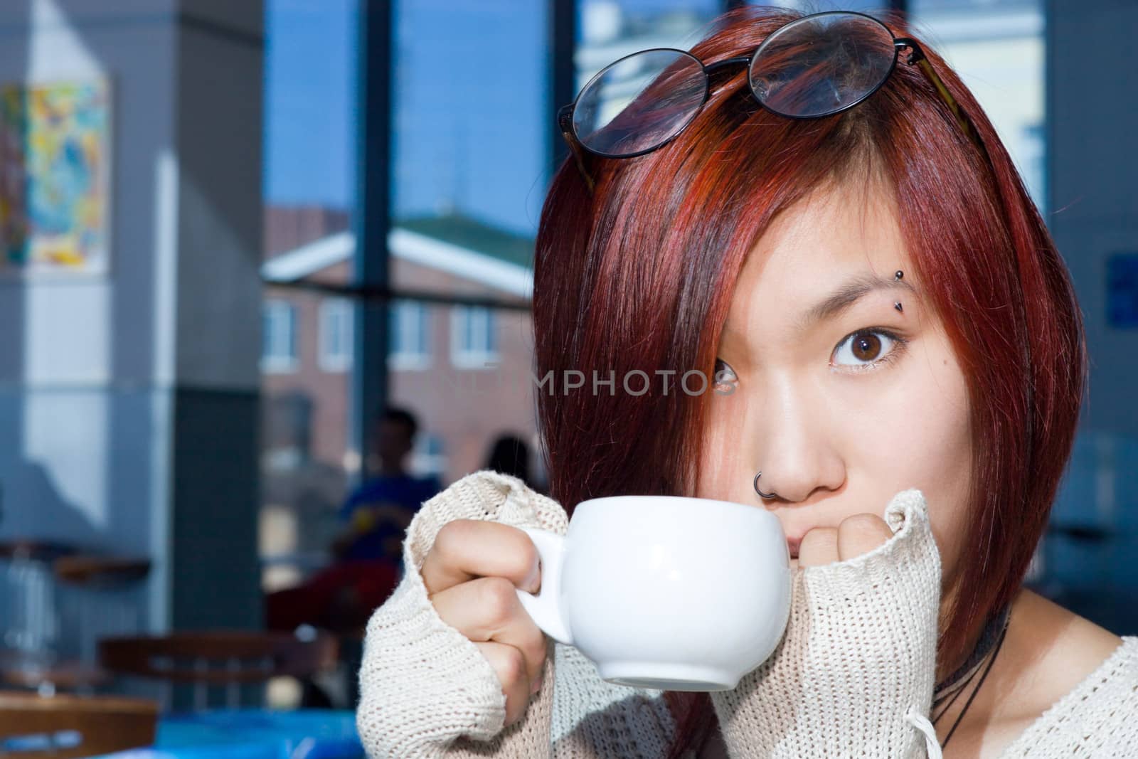 Cafe. Pretty girl having a cup of coffee with a piece of chocolate.