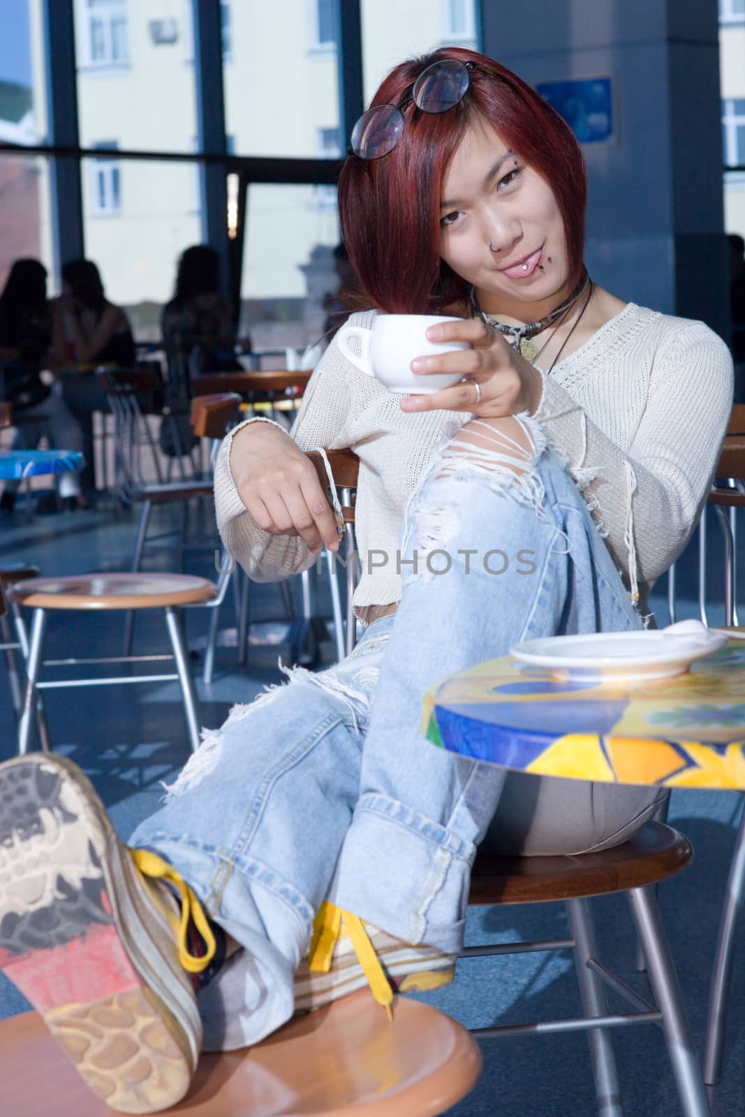 Cafe. Pretty girl having a cup of coffee with a piece of chocolate.