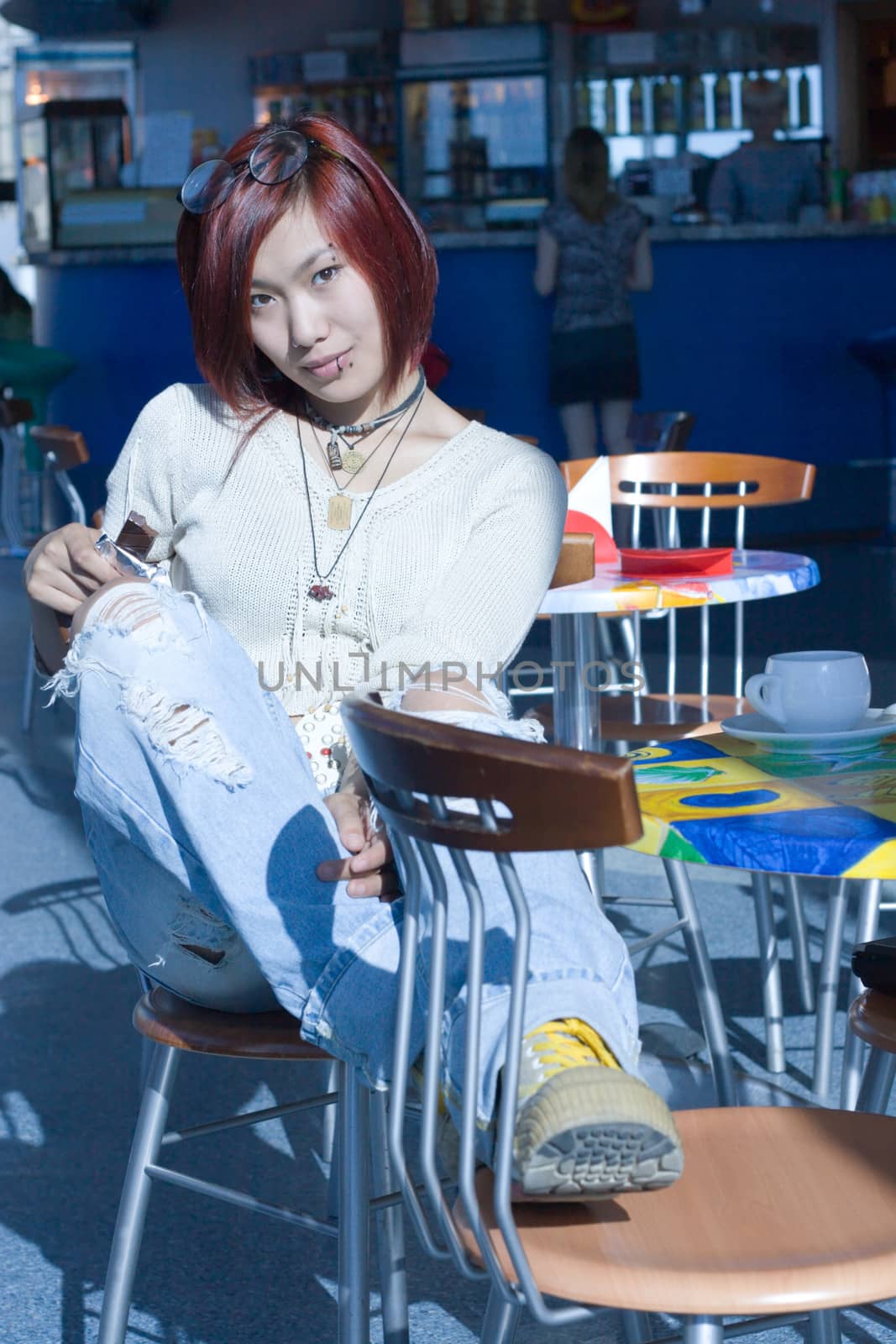 Cafe. Pretty girl having a cup of coffee with a piece of chocolate.