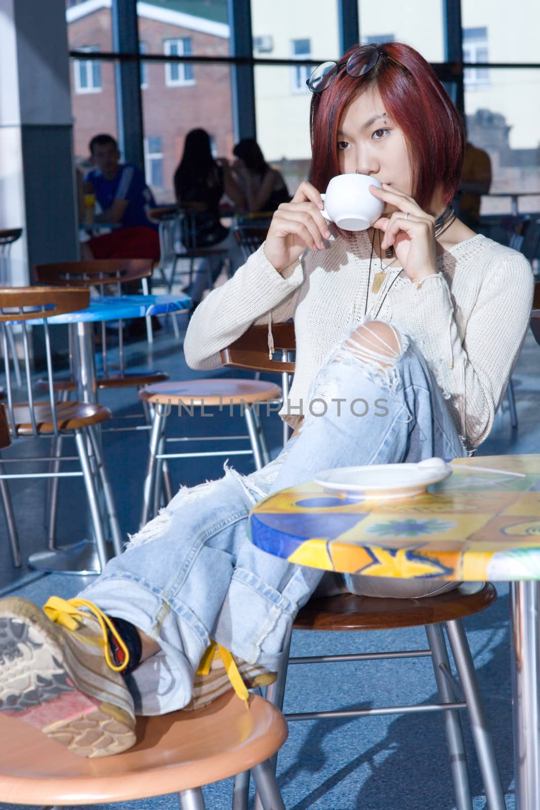 Cafe. Pretty girl having a cup of coffee with a piece of chocolate.