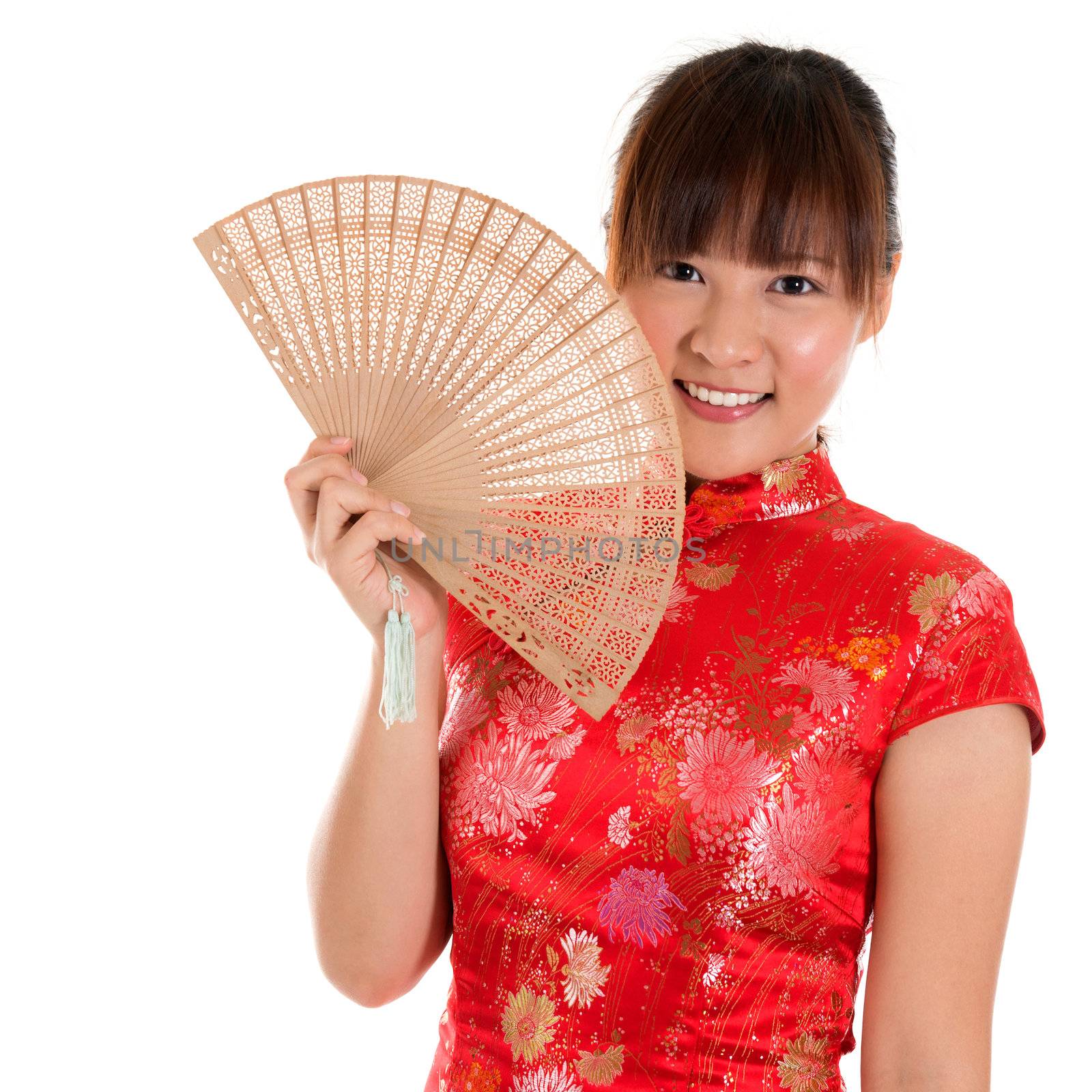 Beautiful Asian girl with Chinese traditional dress Cheongsam holding a Chinese Fan isolated on white background