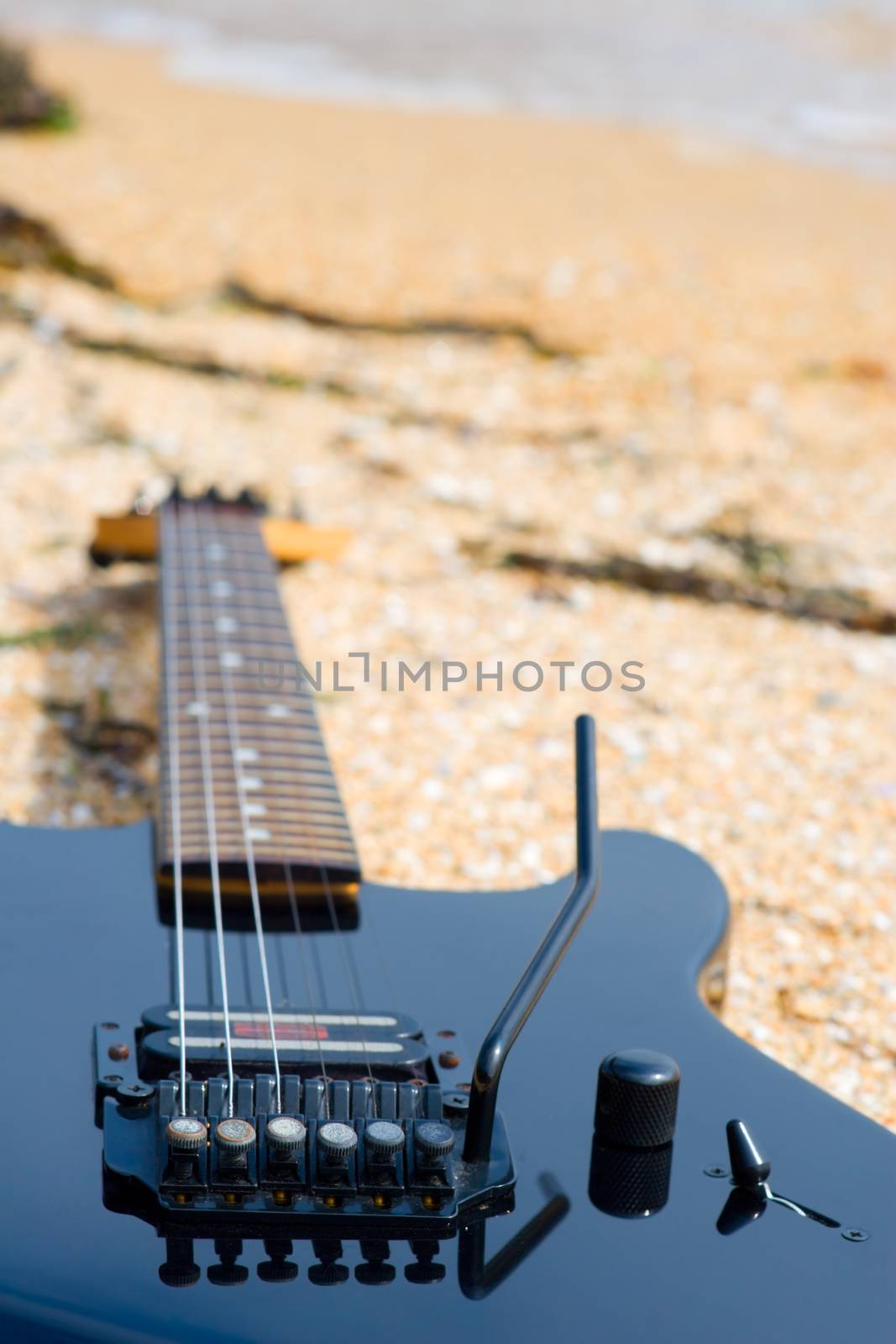 The electroguitar lays on sea coast