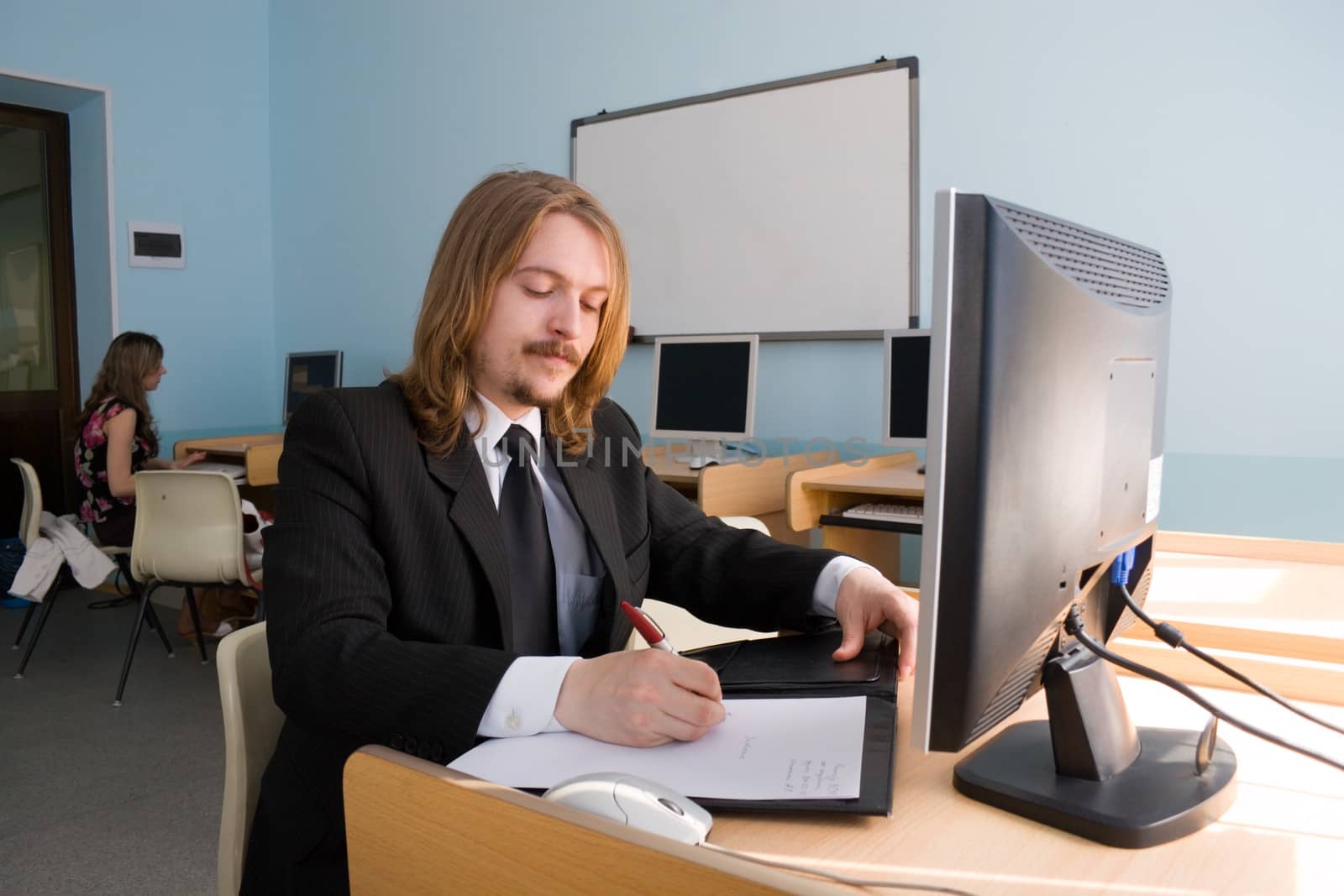 Young businessman is talking by mobile phone & also receives the information by computer.