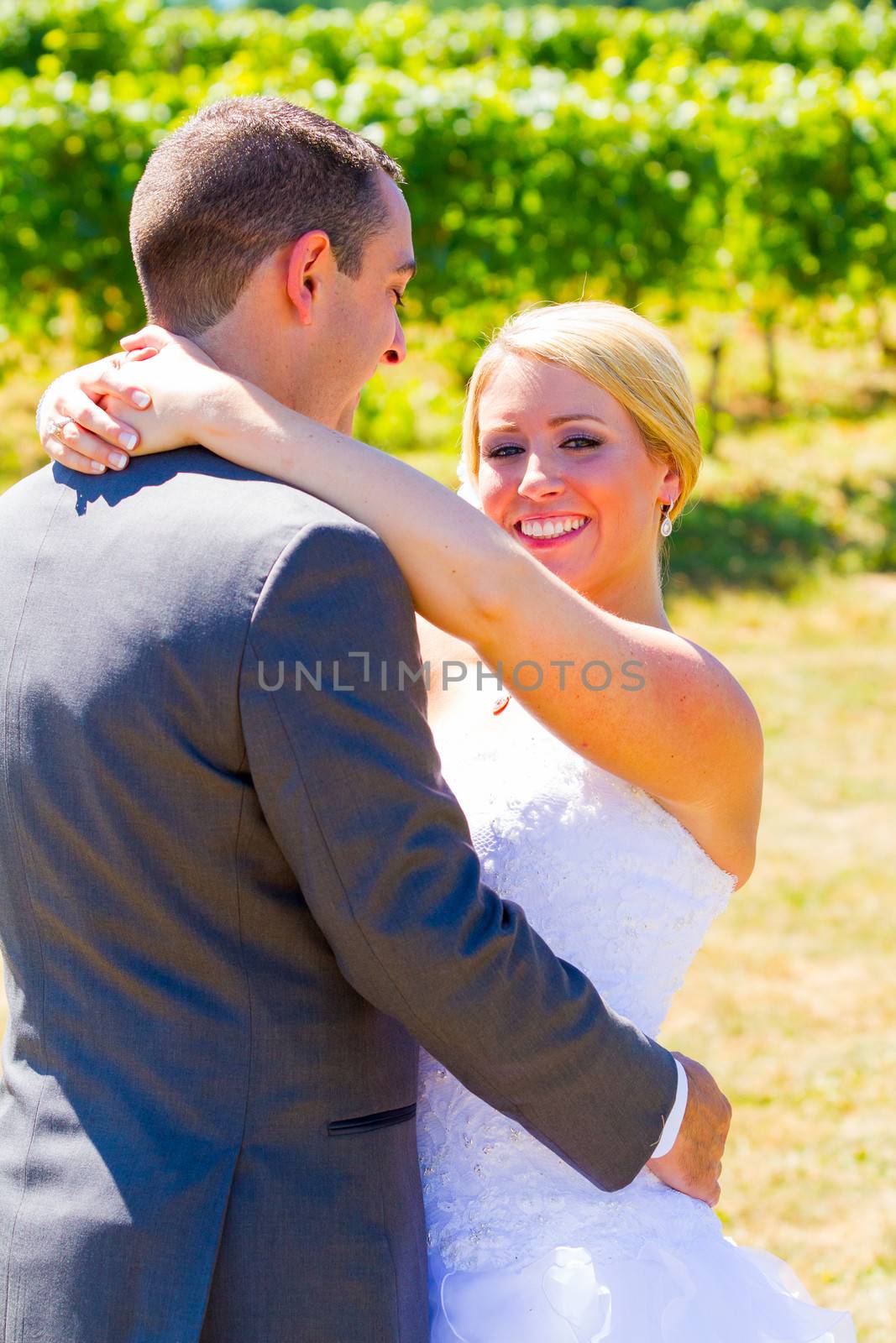 A bride and groom pose for portraits on their wedding day at a winery vineyard outdoors in oregon.