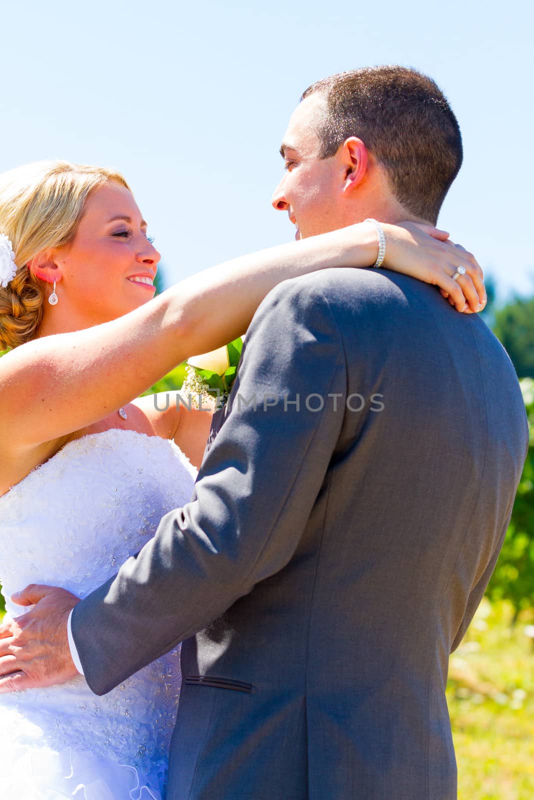 A bride and groom pose for portraits on their wedding day at a winery vineyard outdoors in oregon.