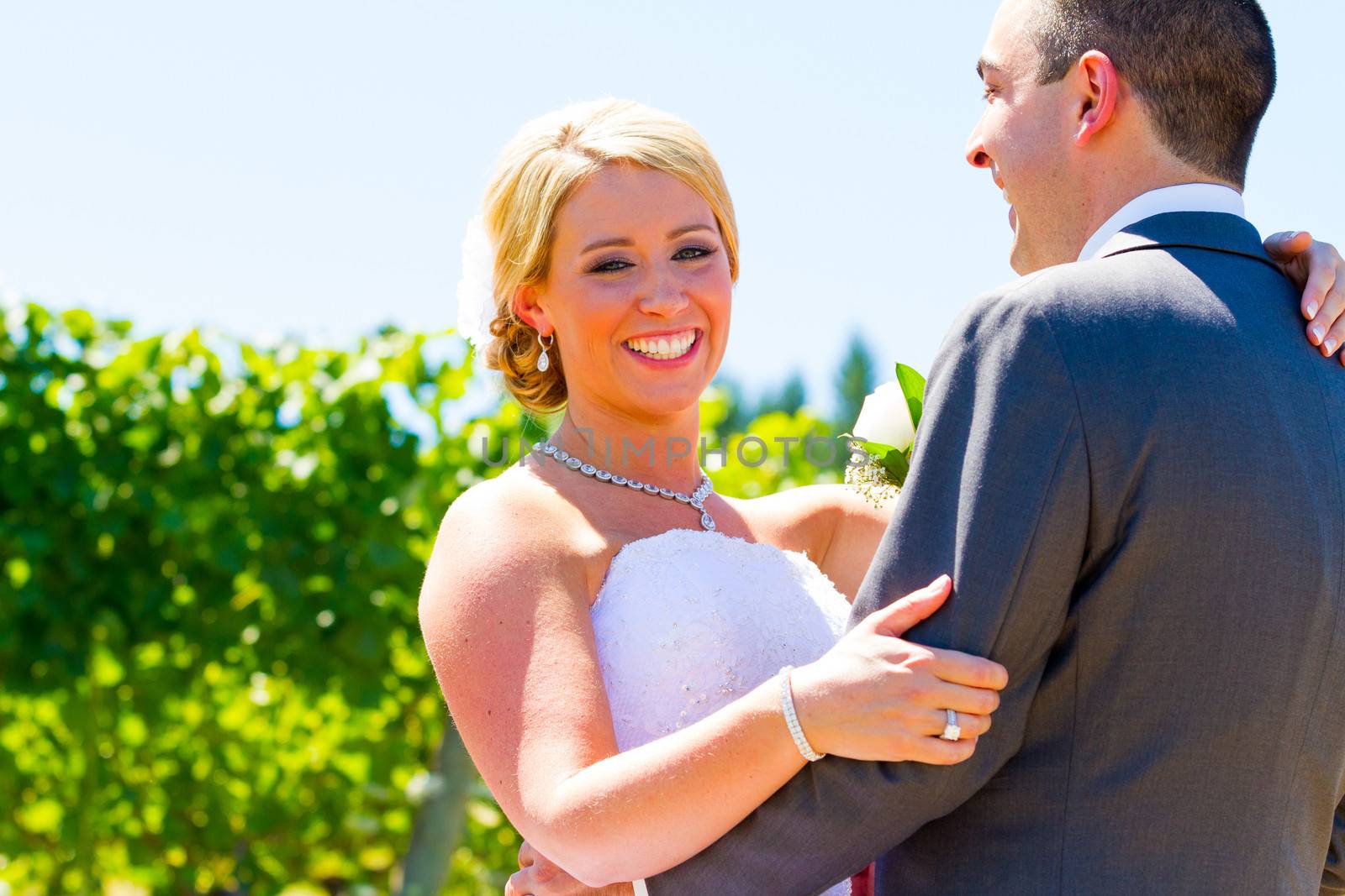 A bride and groom pose for portraits on their wedding day at a winery vineyard outdoors in oregon.