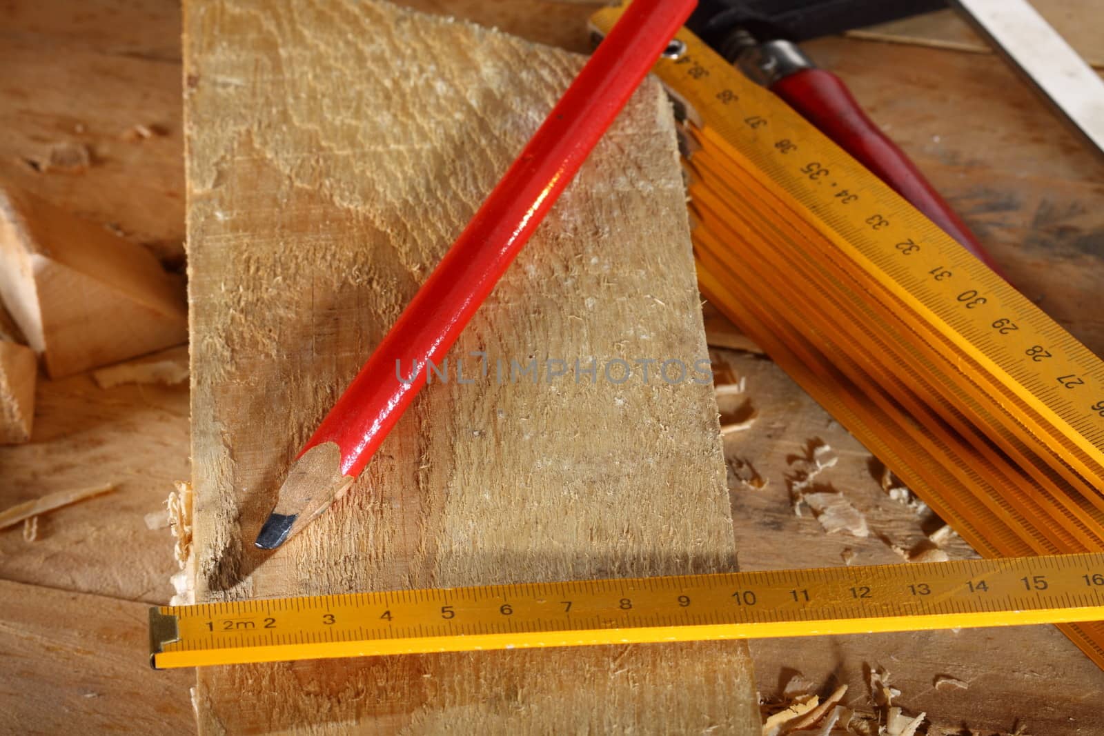 Carpenter's pencil and wooden meter on workshop