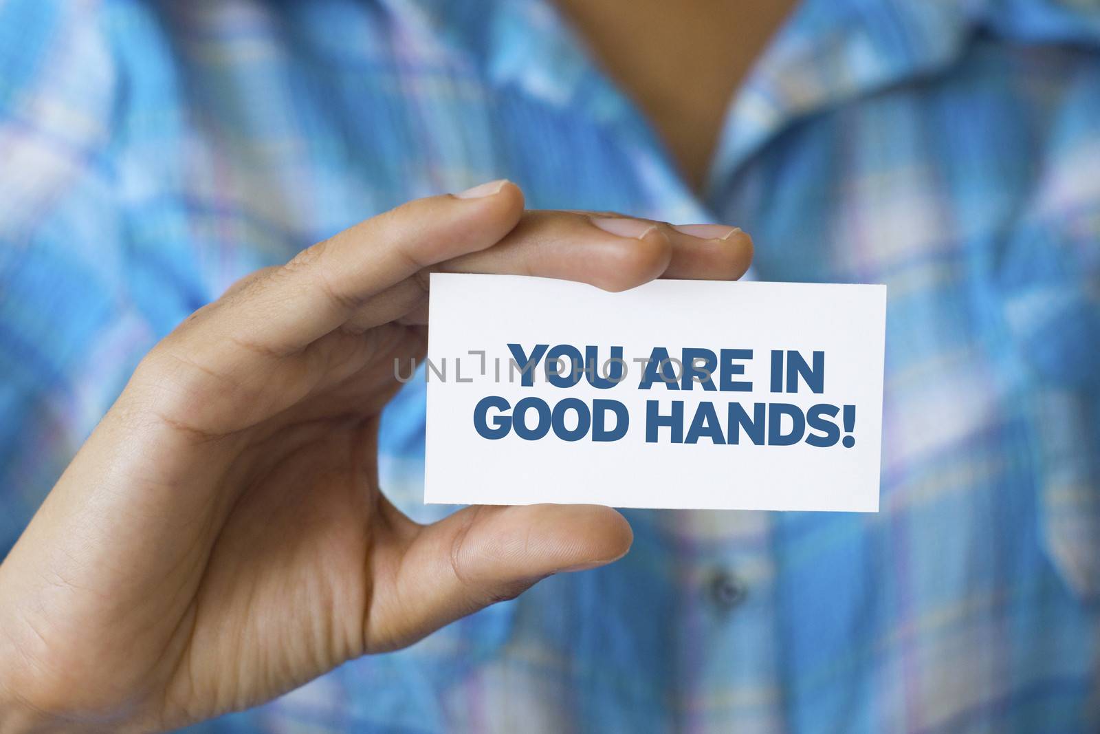 A person holding a white card with the words You are in Good hands