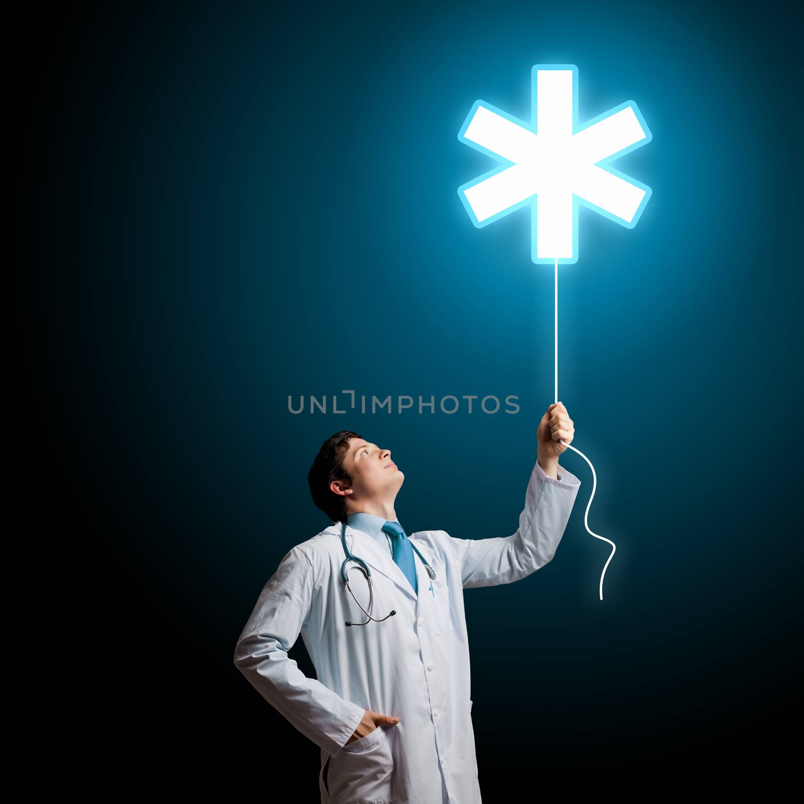 Young male doctor holding balloon with medical sign