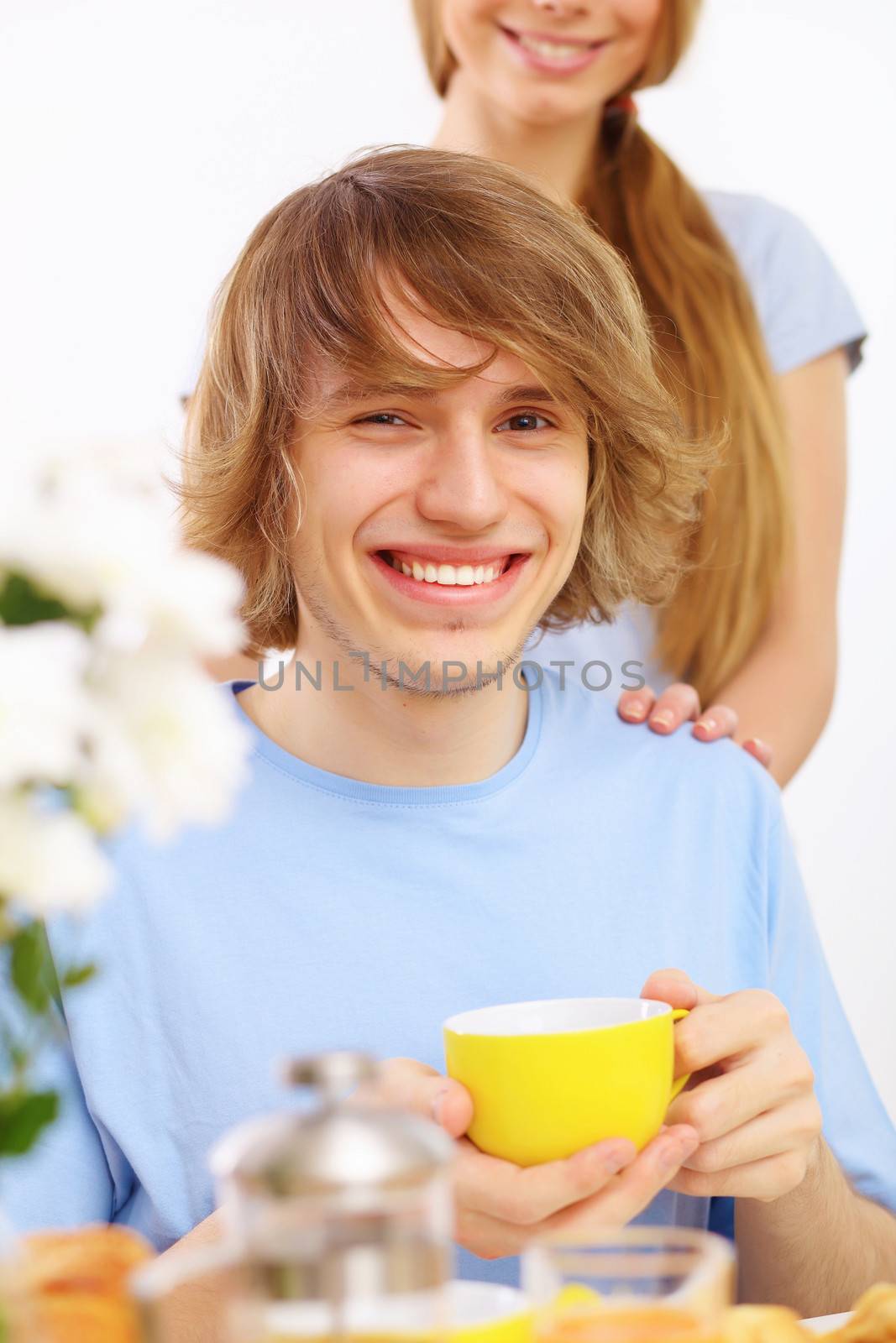 Young happy man drinking tea at home