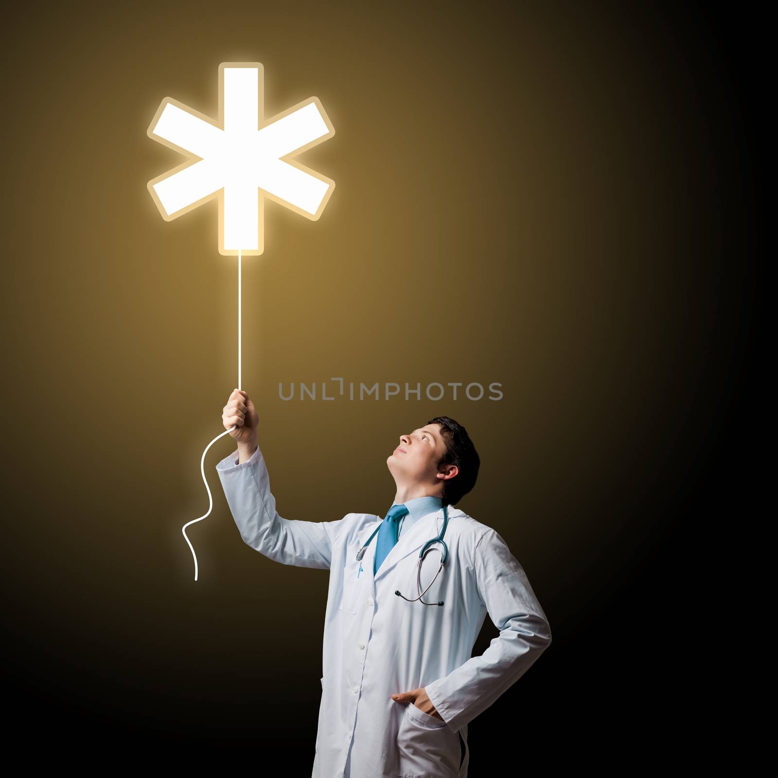 Young male doctor holding balloon with medical sign