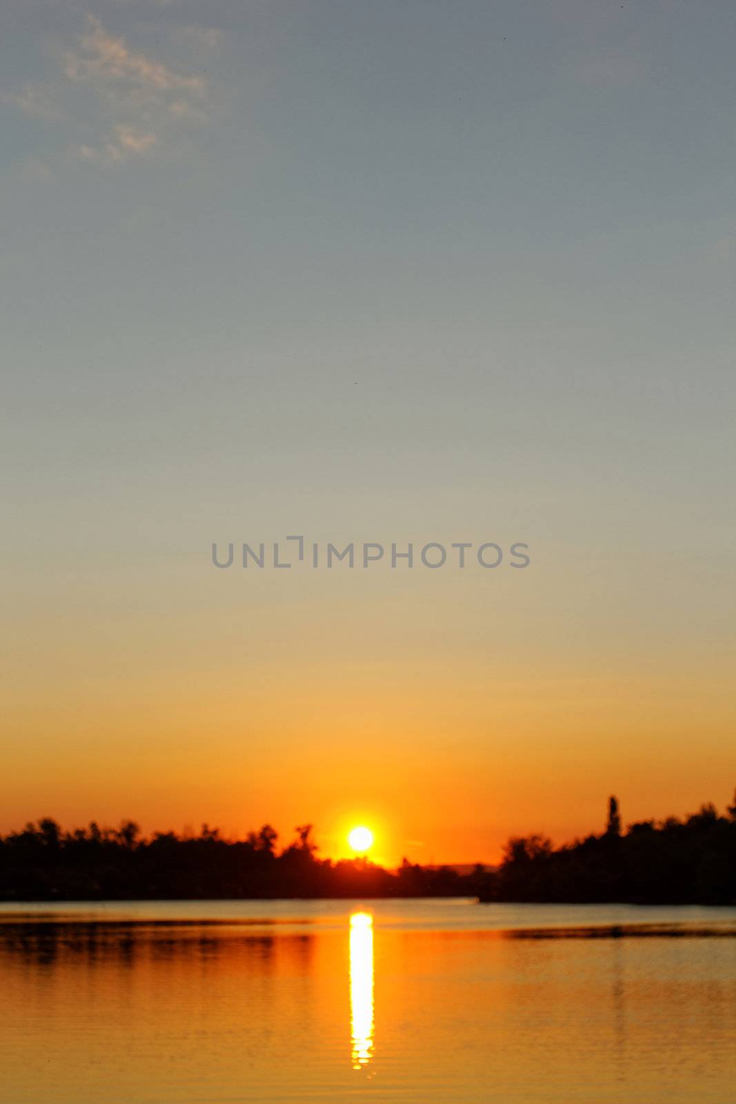 Colorful sunset over tranquil water surface.