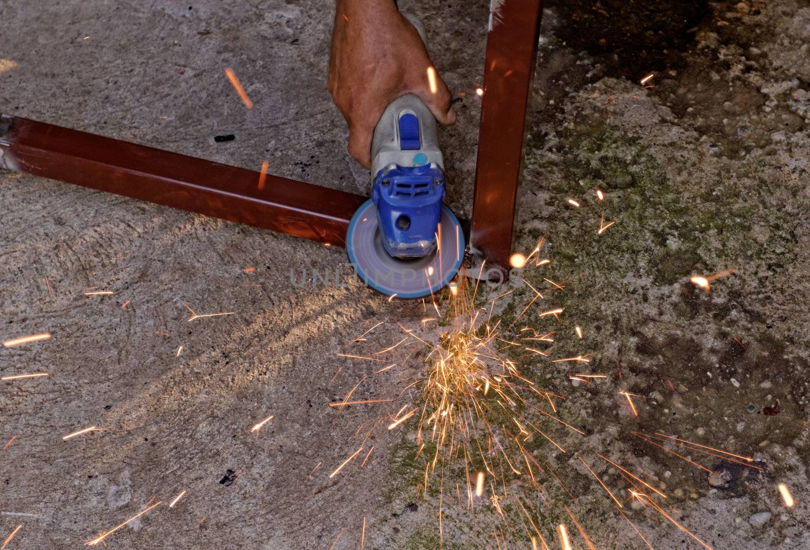 Metal buffing with hand grinder. Sparks while grinding iron.