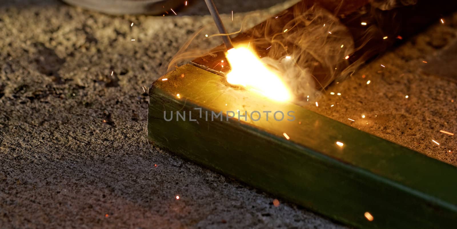 Iron welding with bright light and smoke at manufacturing