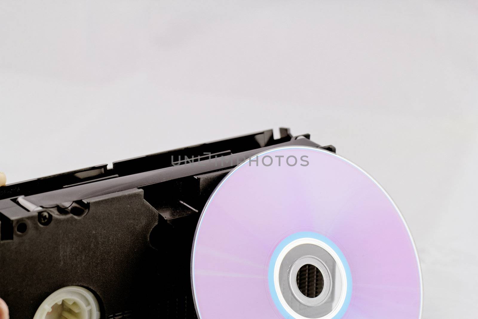 VHS video tape and DVD disk (analog digital) on white background