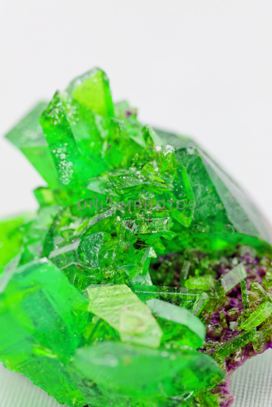 Close up picture about a crystal with emerald color on white background (green crystal)