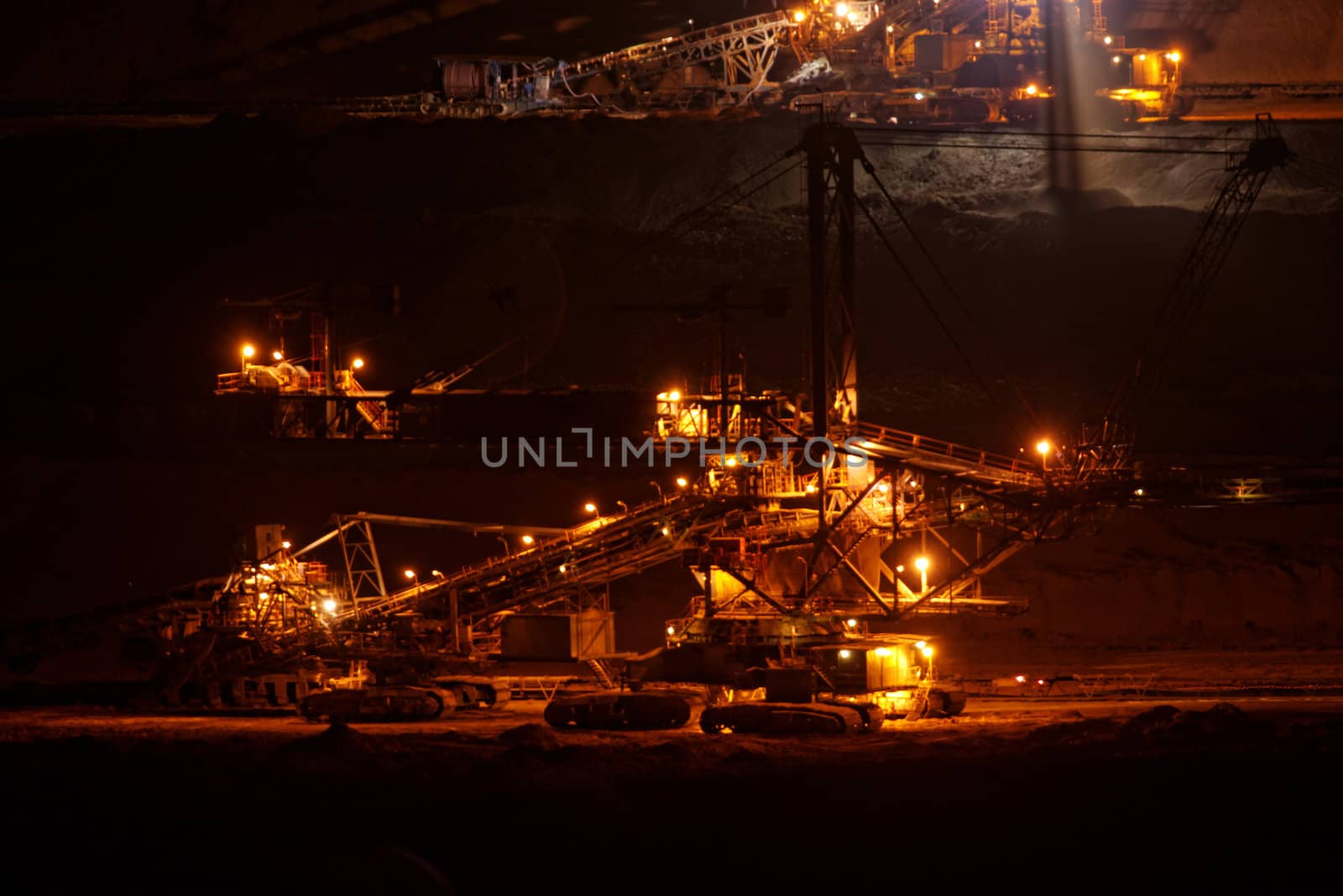 Coal mining in an open pit with huge industrial machine at night shoot