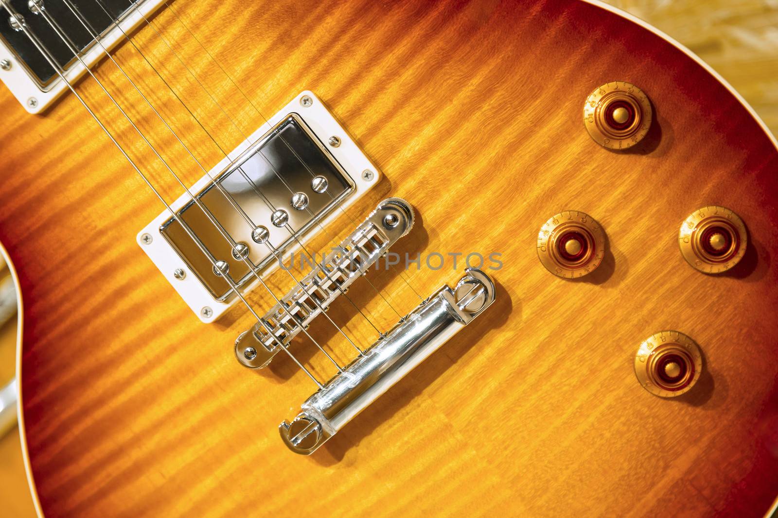 Close up of a Lacquer electric guitar on wooden surface.