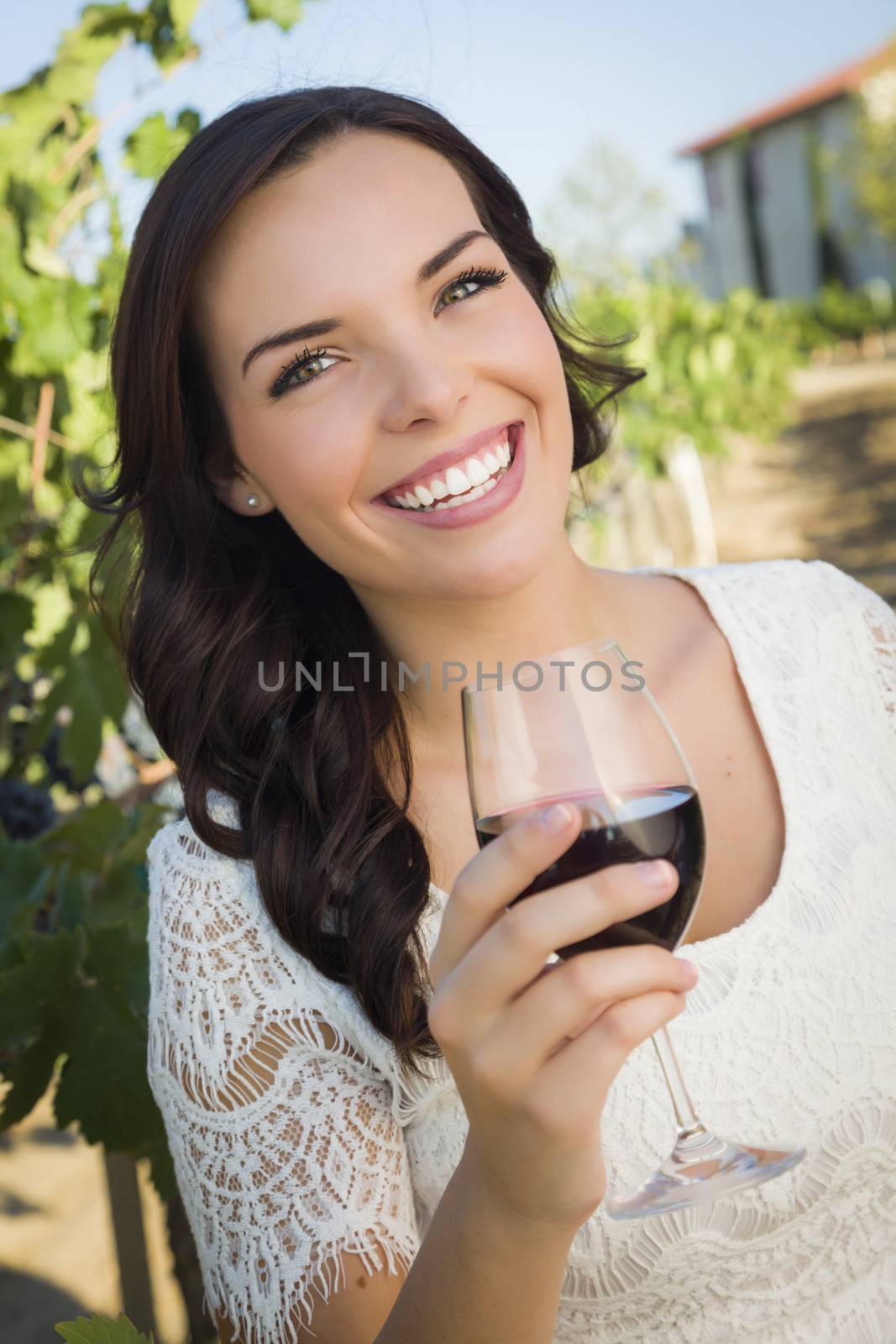 Pretty Mixed Race Young Adult Woman Enjoying A Glass of Wine in the Vineyard.