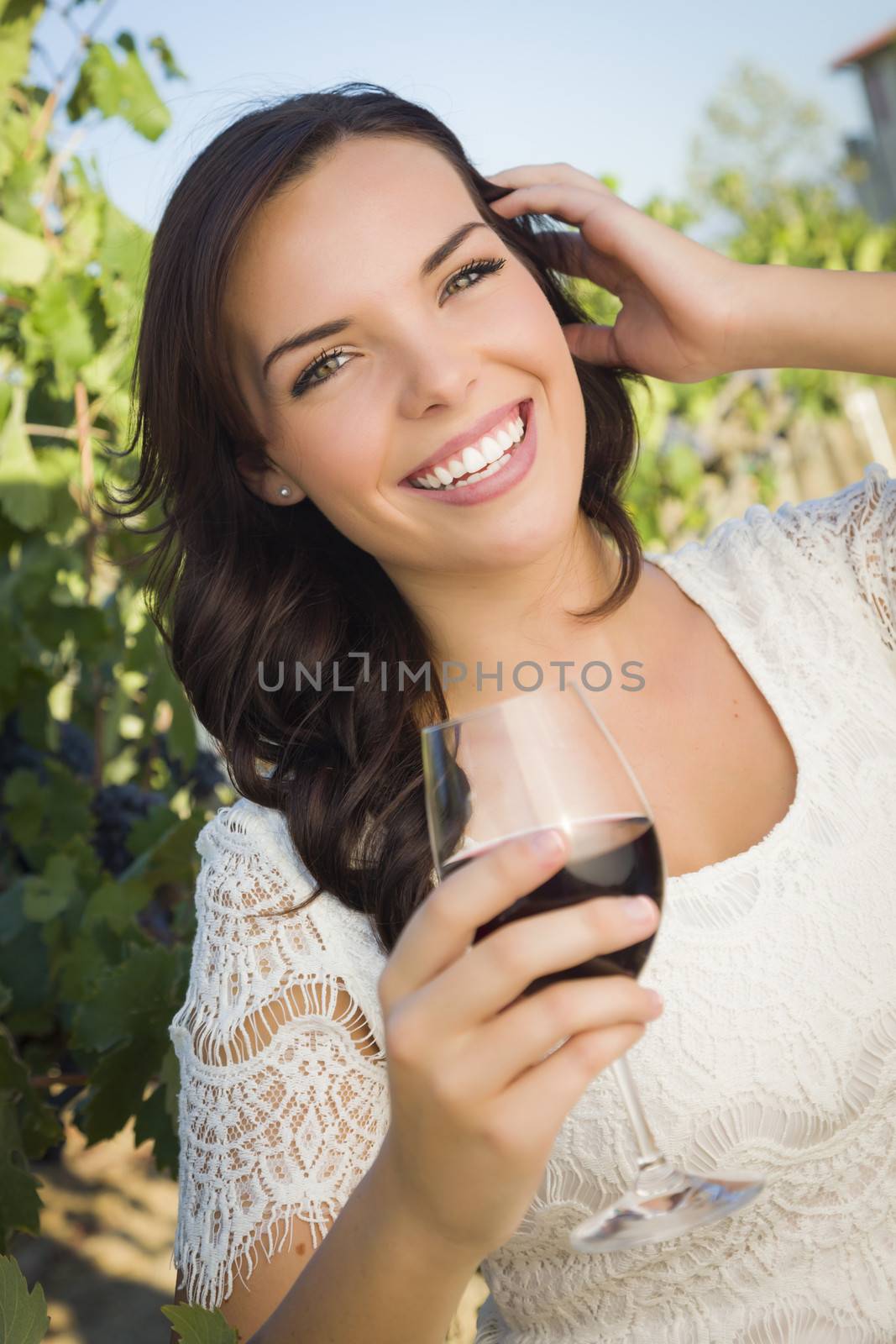 Young Adult Woman Enjoying A Glass of Wine in Vineyard by Feverpitched