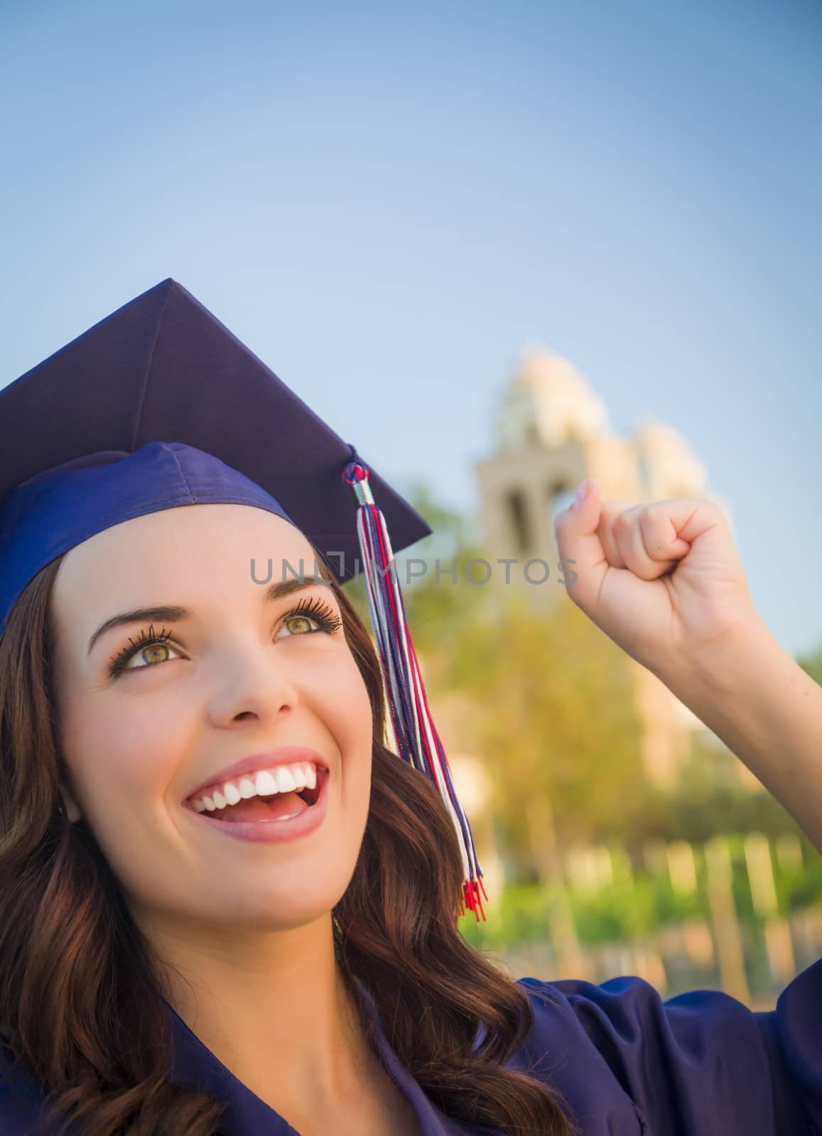 Happy Graduating Mixed Race Woman In Cap and Gown Celebrating on Campus.