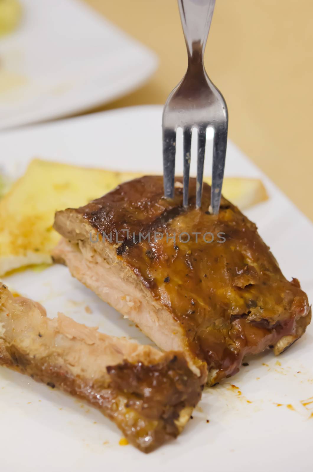 Barbecued Pork Baby Back Ribs with fork and garlic bread