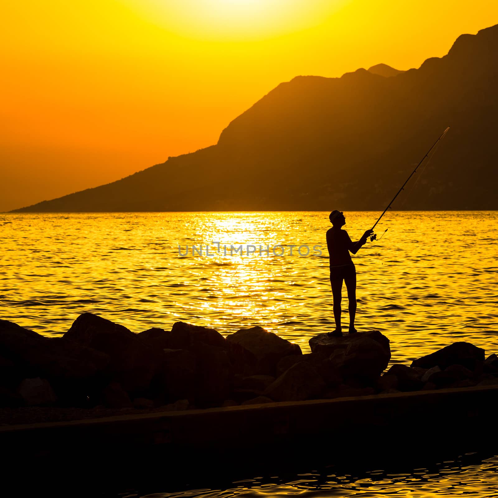Fisherman's silhouette on the beach at colorful sunset by viktor_cap