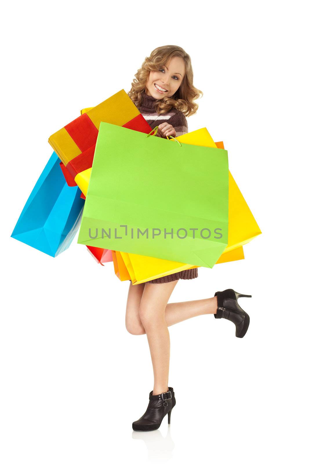 Smiling female holding colorful gift bags, standing on white background