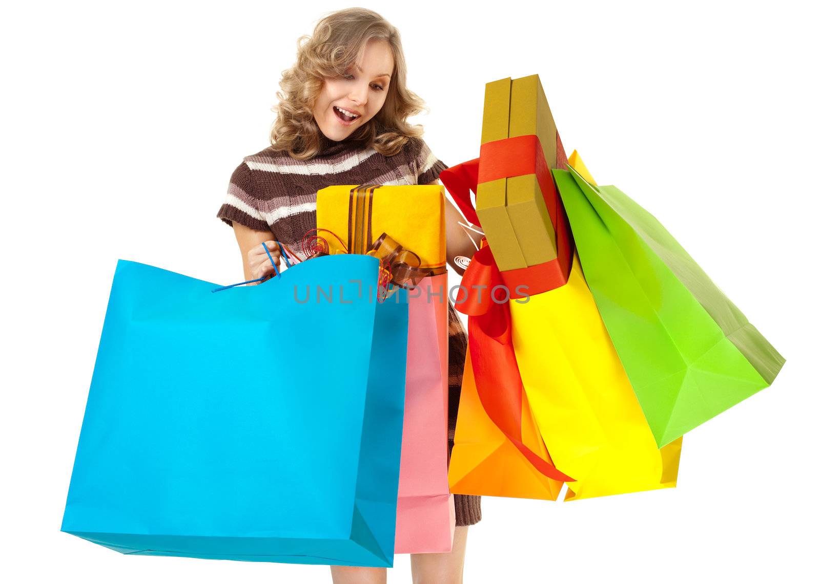 Studio shot of young woman hodling colourful shopping bags with gifts