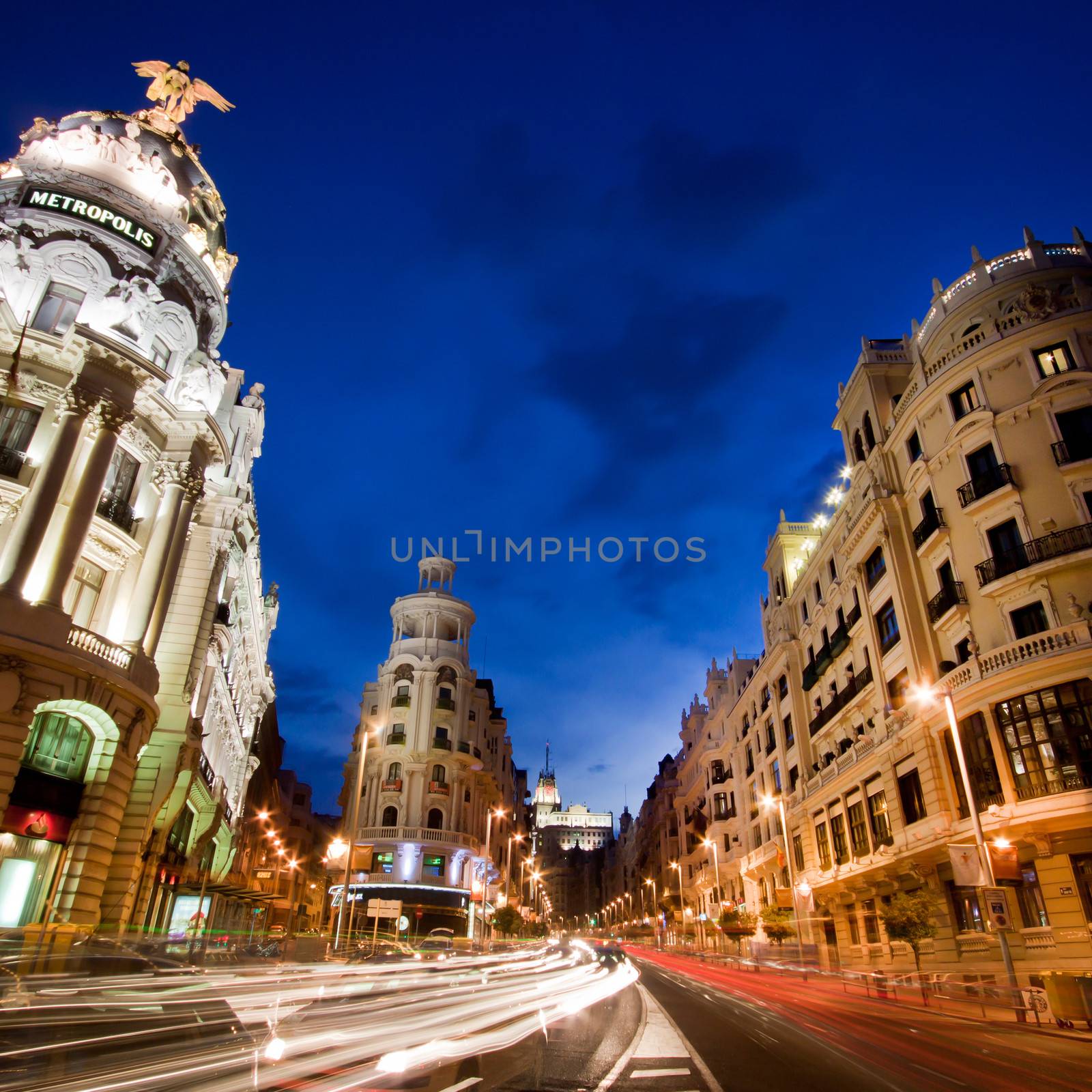 Rays of traffic lights on Gran via street, main shopping street in Madrid at night. Spain.