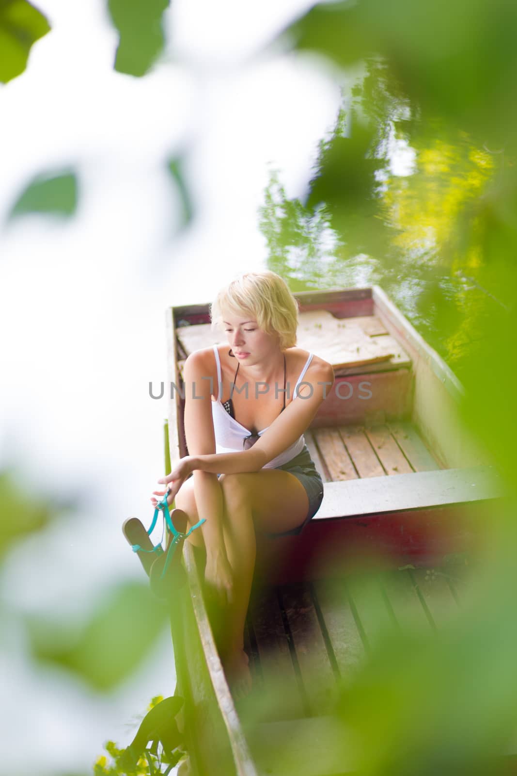 Thoughtful woman on the vintage wooden boat. by kasto
