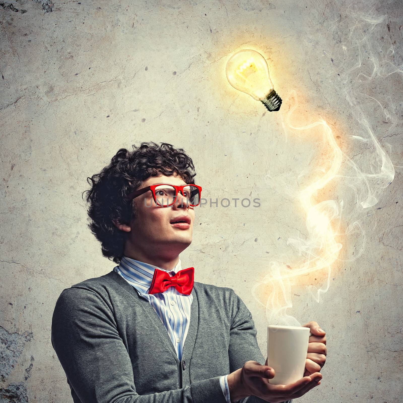 Young man with smoke coming out of a cup and a bulb experimenting
