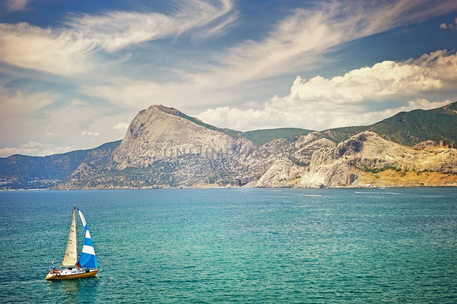 yacht in the Bay of Sudak in the background of mountains by kosmsos111