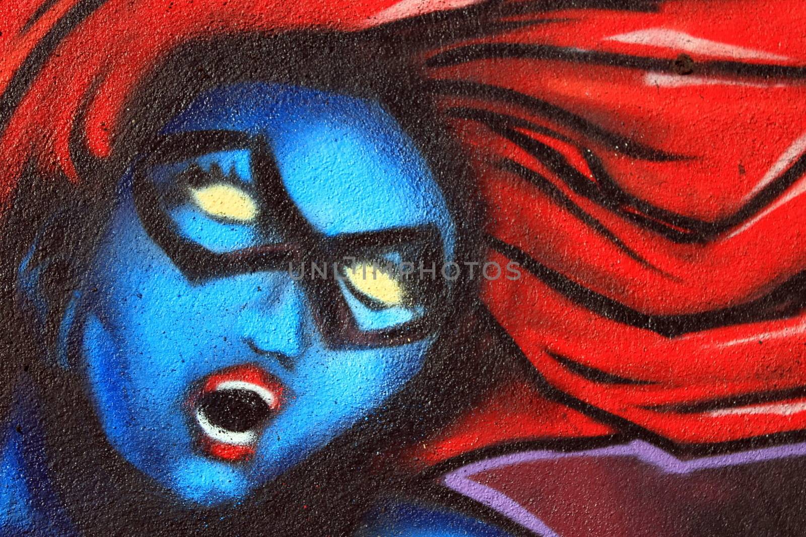 Graffiti on a wall of the blue woman head with red hair