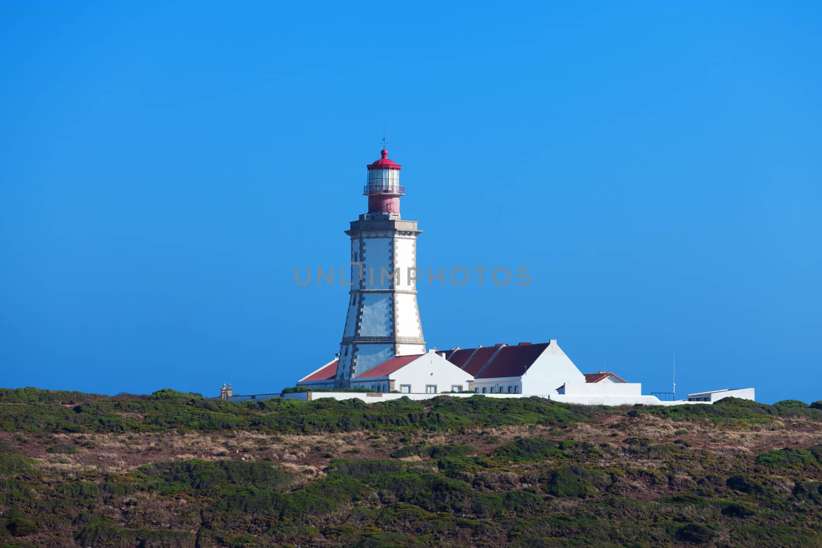 Lighthouse on a rock against the blue sky