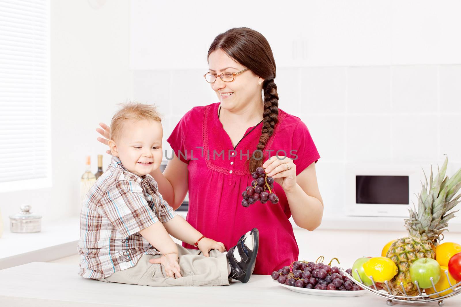 Mother and child with fruits in the kitchen