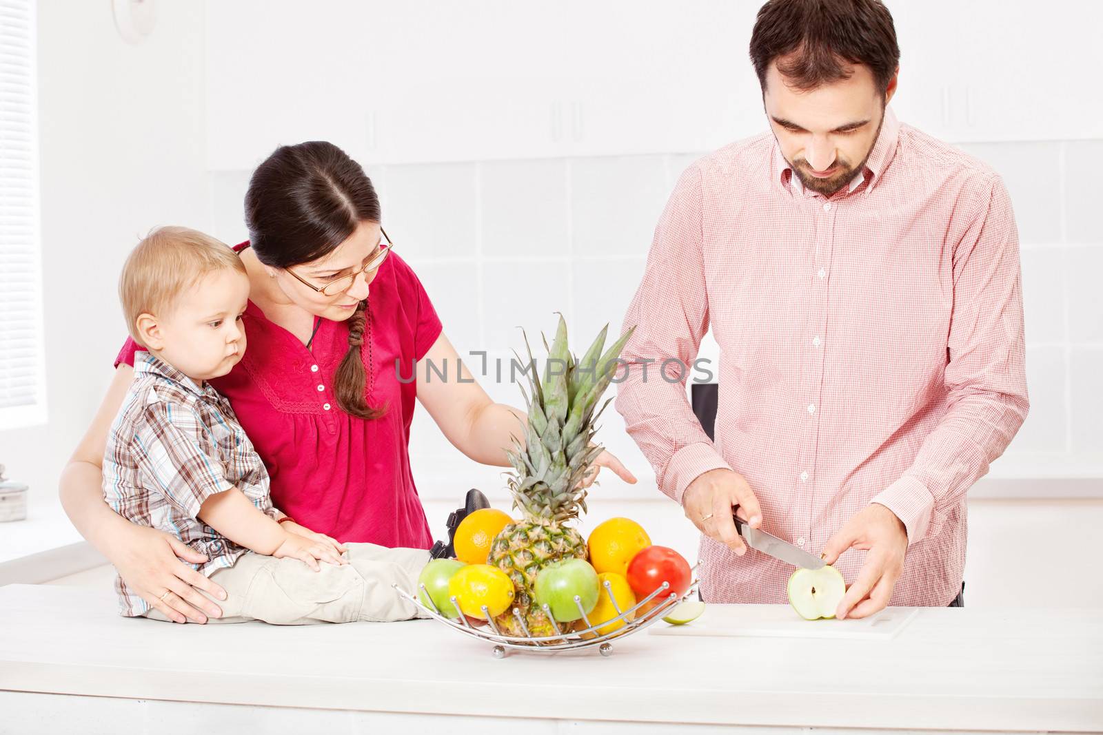 Father is preparing fruit for child  by imarin