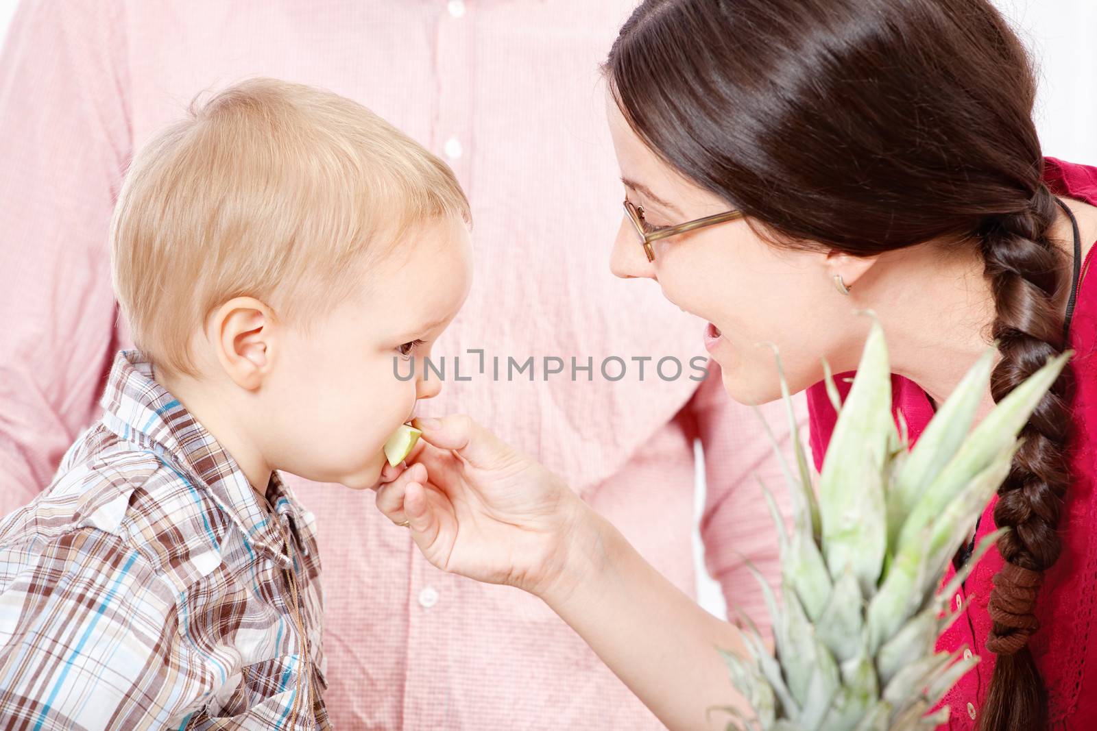 Mother feeding child with apple