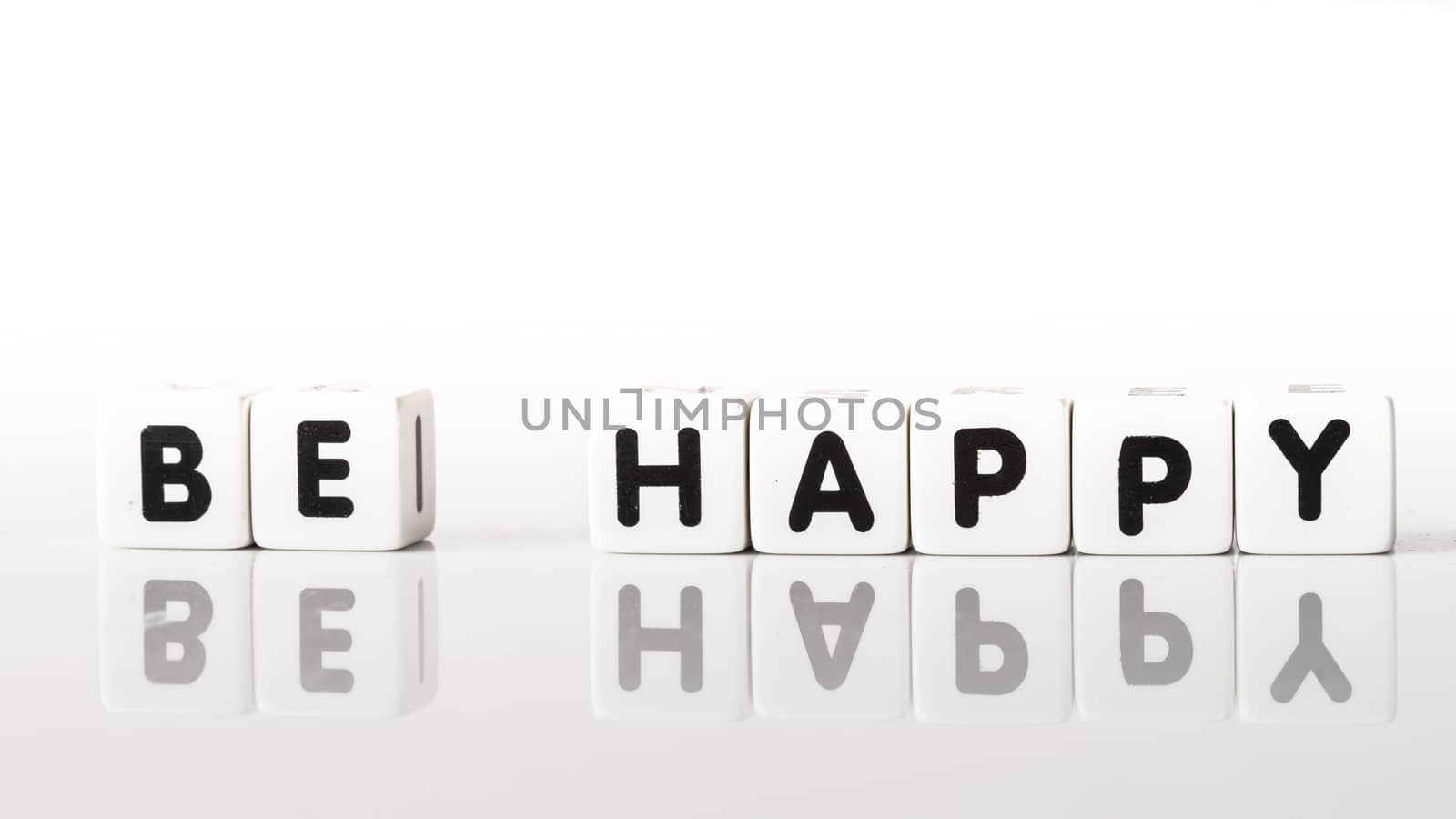 Be Happy spelled in black letters reflected on white background