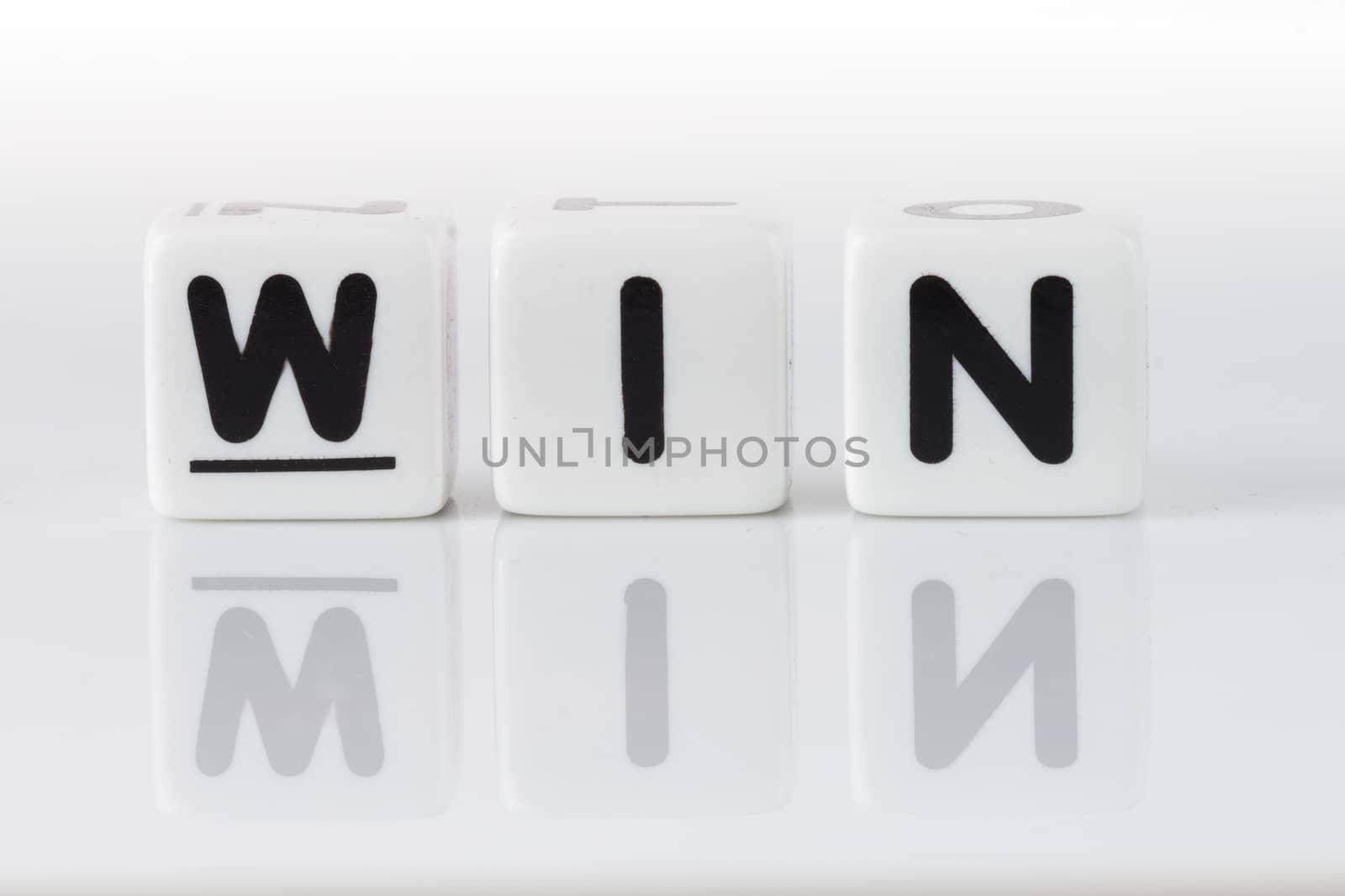 Win spelled in dice letters reflected on white isolated background