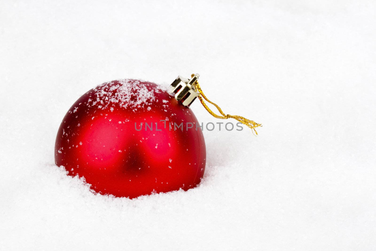 Red christmas ball in the snow