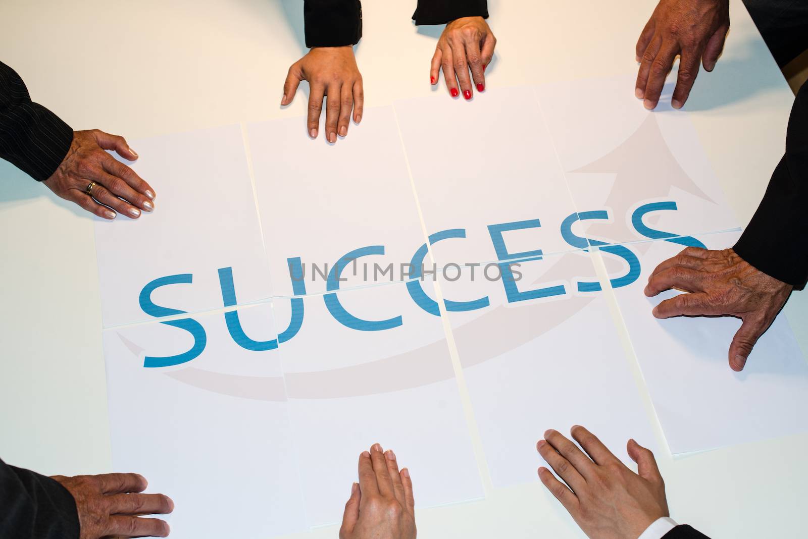 Teamwork means Success : Group of business people assembling the word success spread over several papers - represent team support and help concept